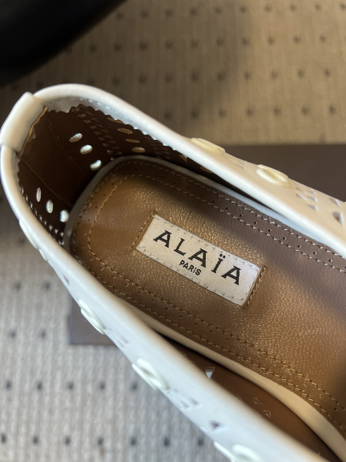 ALAÏ* 26ss 早春新款平底圆形镂空玛丽珍鞋单鞋鞋面采用镂空设计，形成密集的圆形孔洞纹理，兼具装饰