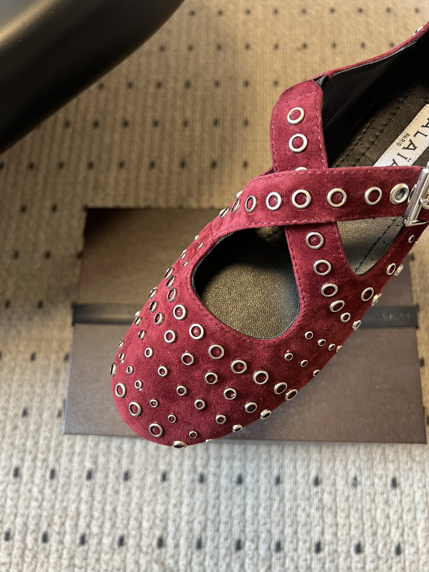 ALAÏ* 26ss 早春新款平底圆形镂空交叉绑带玛丽珍鞋单鞋鞋面采用镂空设计，形成密集的圆形孔洞纹理，