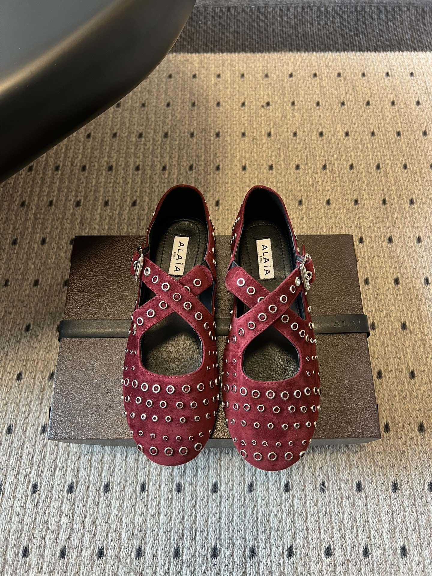 ALAÏ* 26ss 早春新款平底圆形镂空交叉绑带玛丽珍鞋单鞋鞋面采用镂空设计，形成密集的圆形孔洞纹理，