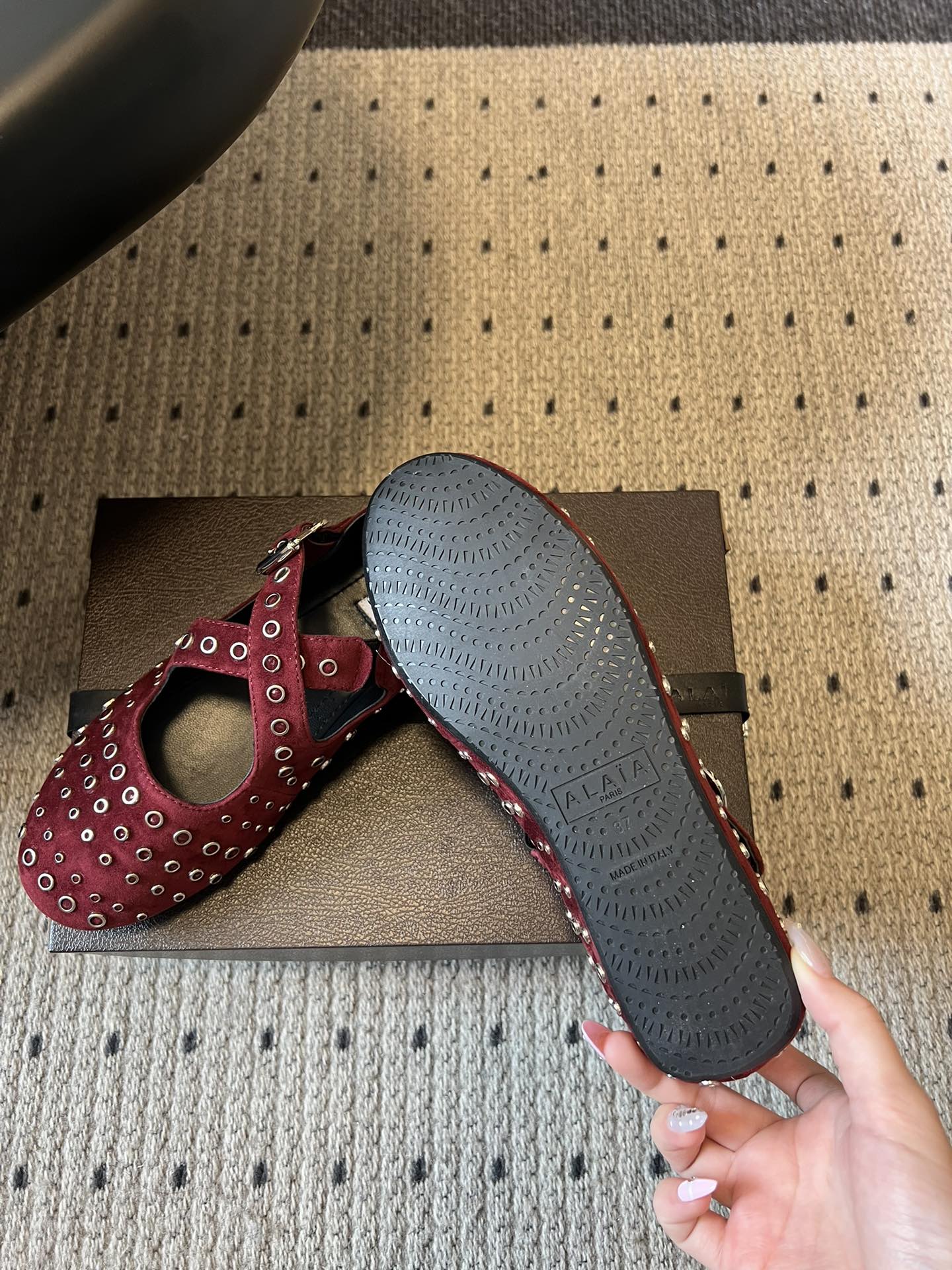 ALAÏ* 26ss 早春新款平底圆形镂空交叉绑带玛丽珍鞋单鞋鞋面采用镂空设计，形成密集的圆形孔洞纹理，