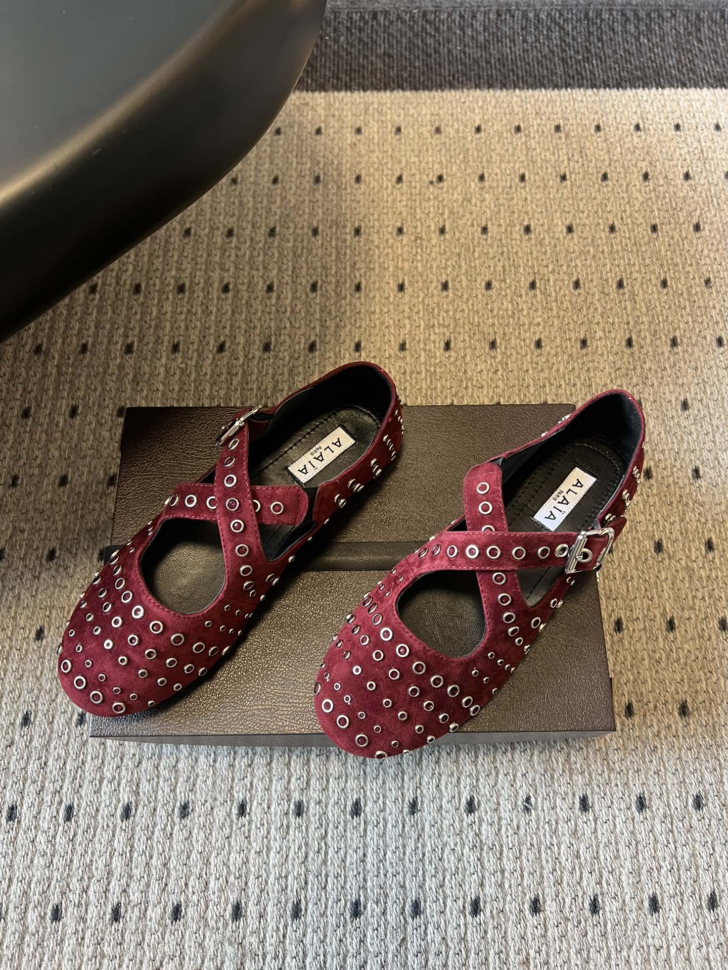 ALAÏ* 26ss 早春新款平底圆形镂空交叉绑带玛丽珍鞋单鞋鞋面采用镂空设计，形成密集的圆形孔洞纹理，