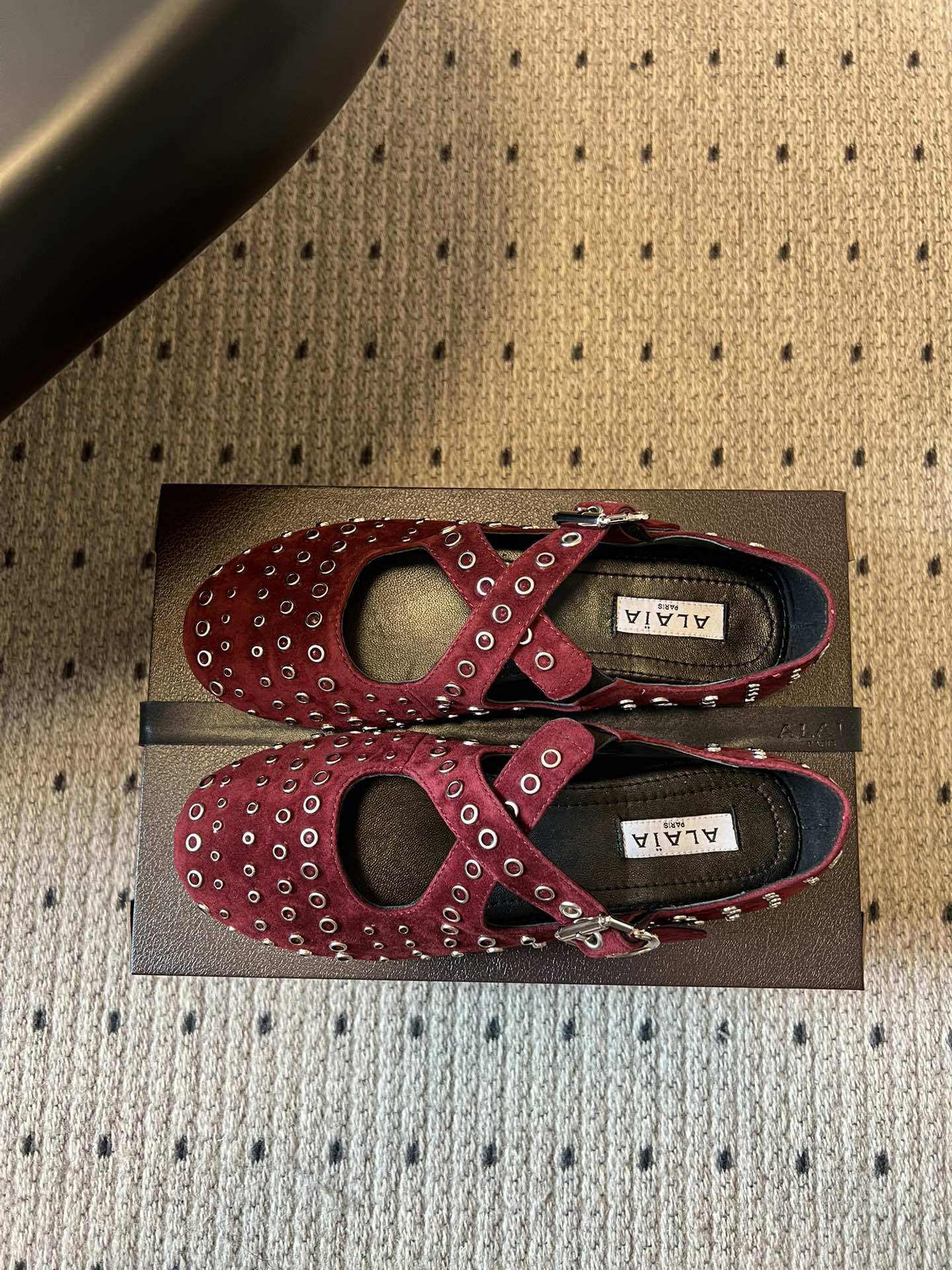 ALAÏ* 26ss 早春新款平底圆形镂空交叉绑带玛丽珍鞋单鞋鞋面采用镂空设计，形成密集的圆形孔洞纹理，
