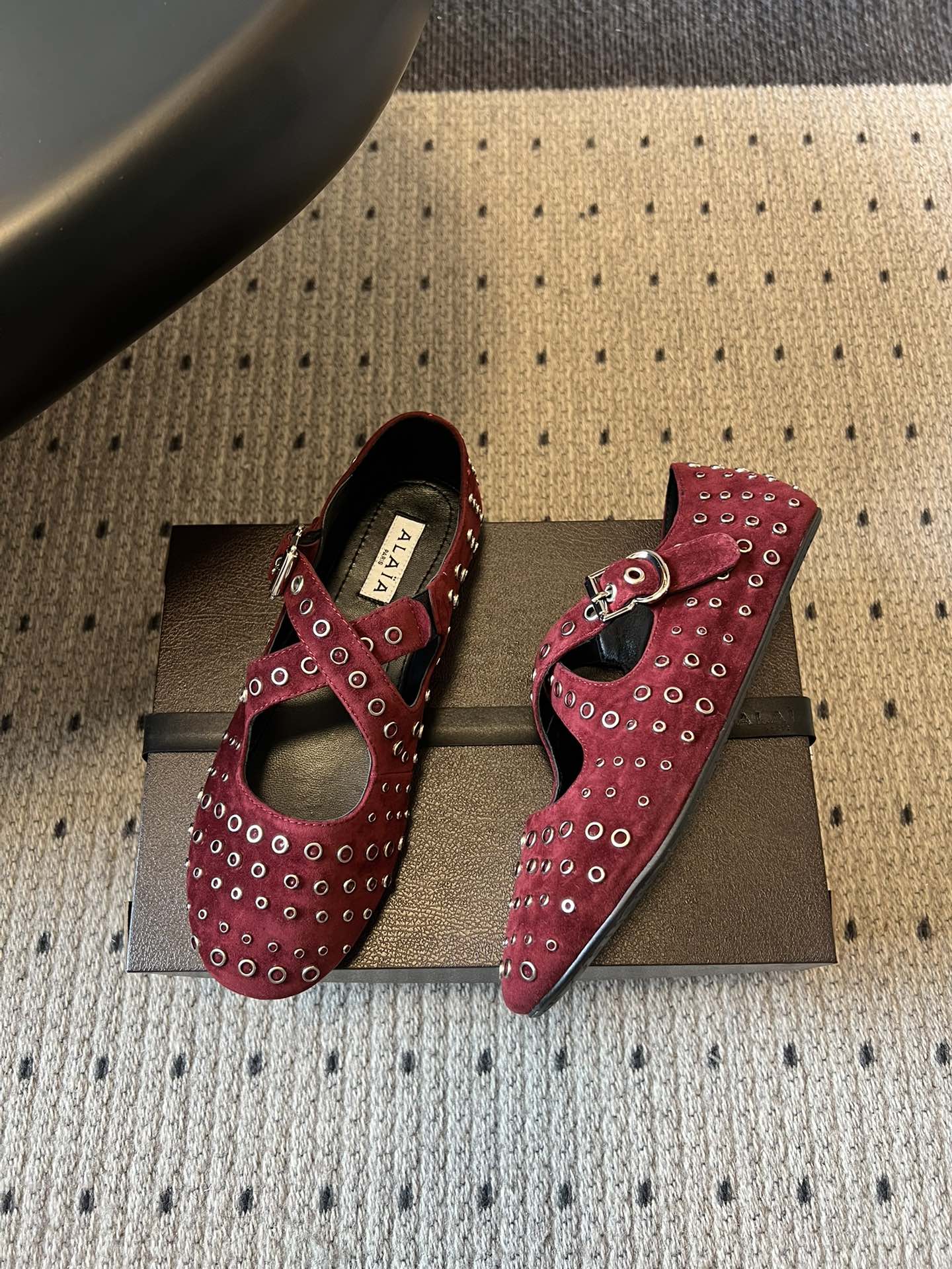 ALAÏ* 26ss 早春新款平底圆形镂空交叉绑带玛丽珍鞋单鞋鞋面采用镂空设计，形成密集的圆形孔洞纹理，