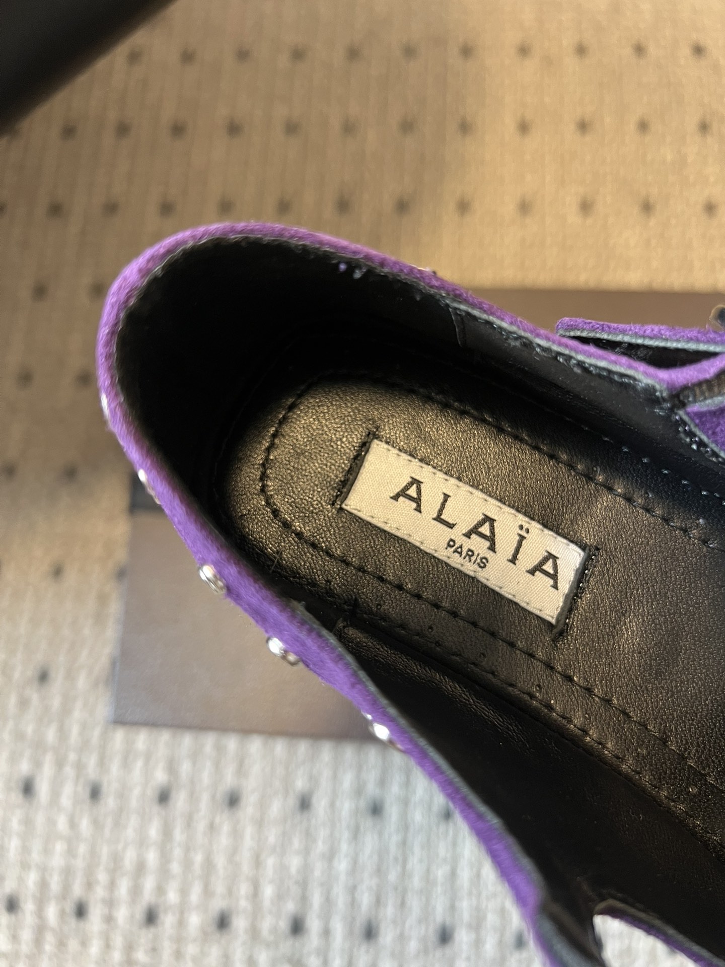 ALAÏ* 26ss 早春新款平底圆形镂空交叉绑带玛丽珍鞋单鞋鞋面采用镂空设计，形成密集的圆形孔洞纹理，