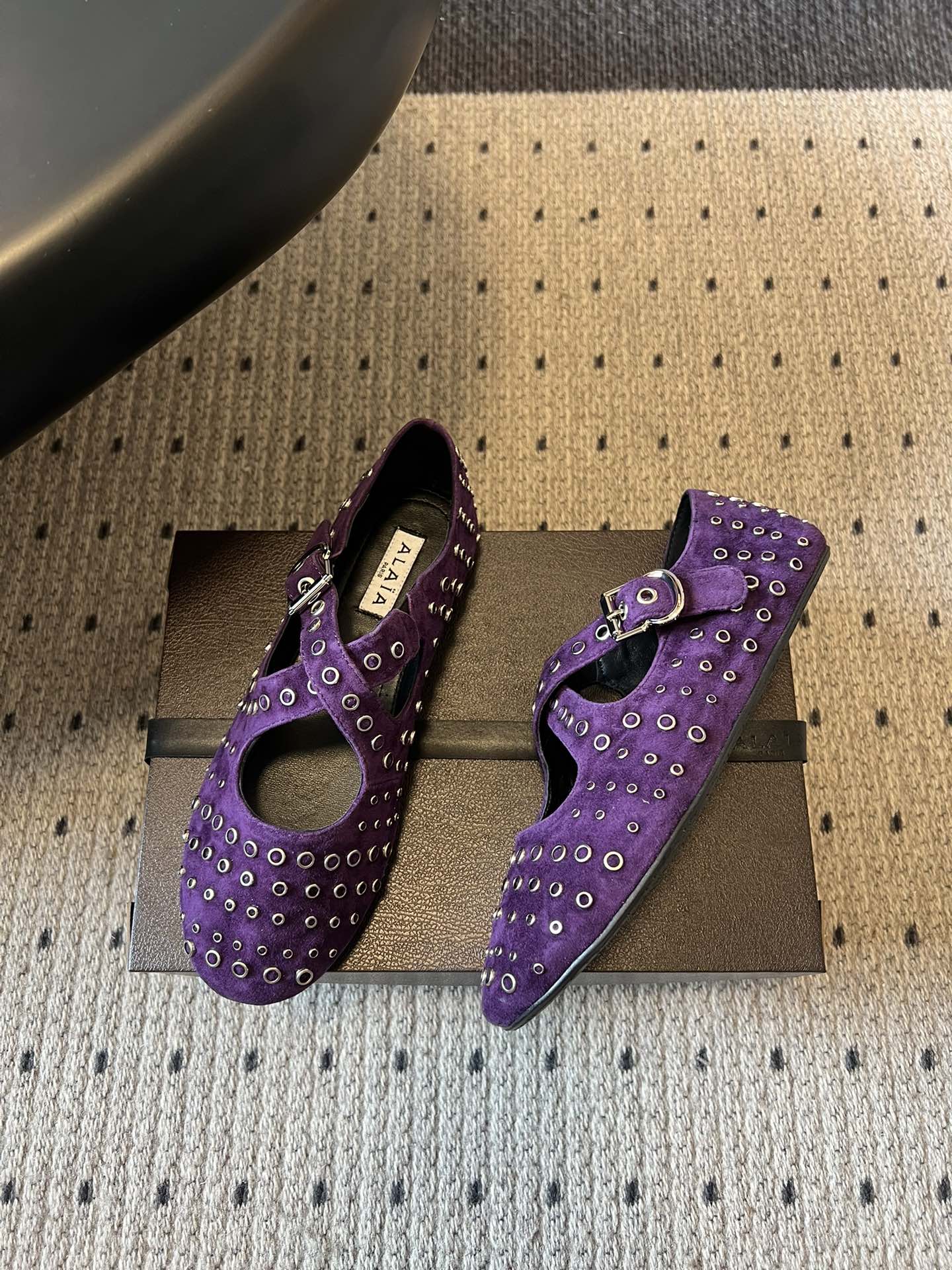 ALAÏ* 26ss 早春新款平底圆形镂空交叉绑带玛丽珍鞋单鞋鞋面采用镂空设计，形成密集的圆形孔洞纹理，