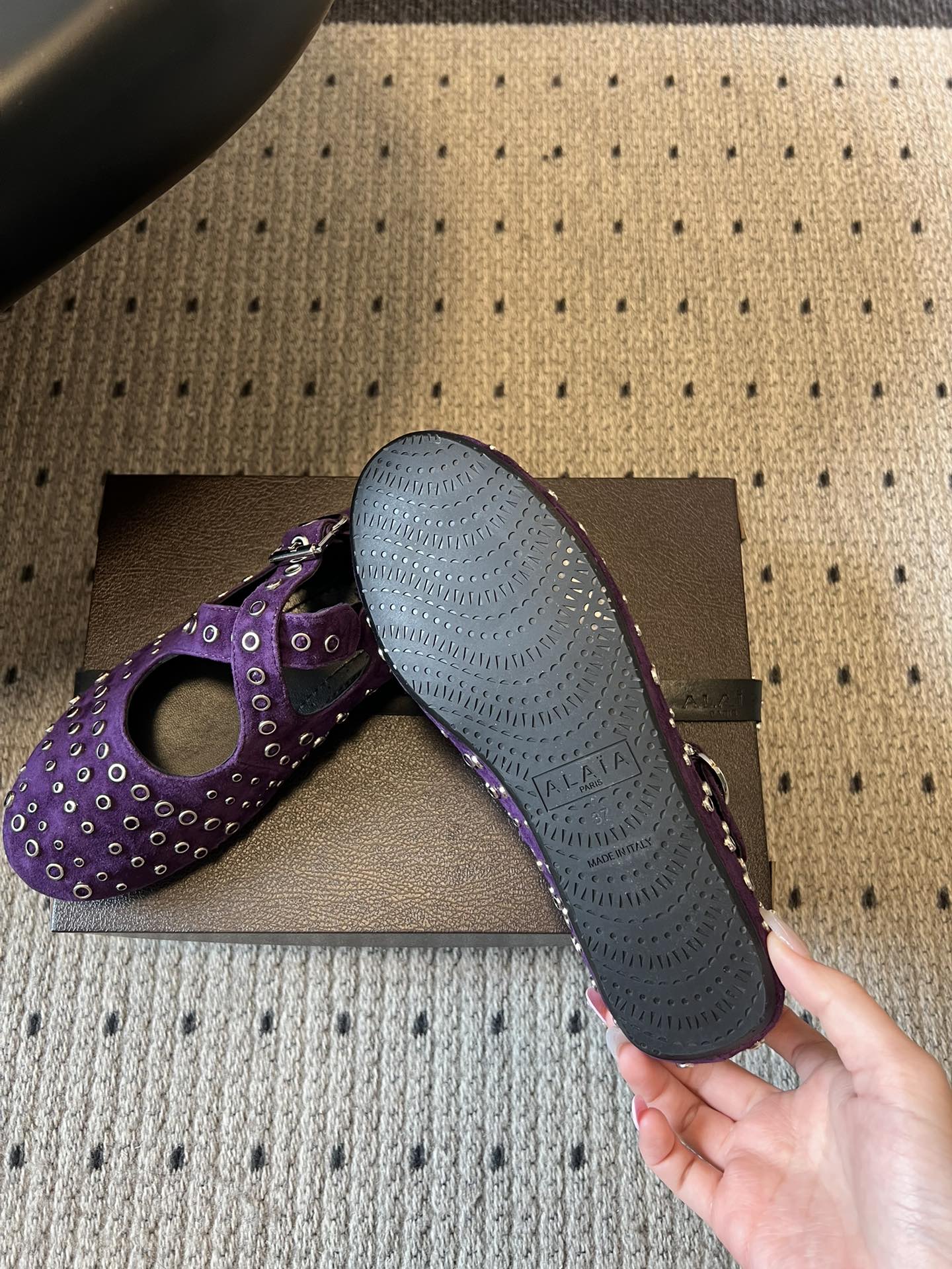 ALAÏ* 26ss 早春新款平底圆形镂空交叉绑带玛丽珍鞋单鞋鞋面采用镂空设计，形成密集的圆形孔洞纹理，