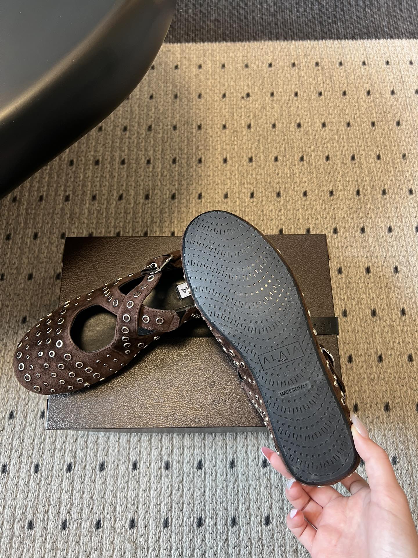 ALAÏ* 26ss 早春新款平底圆形镂空交叉绑带玛丽珍鞋单鞋鞋面采用镂空设计，形成密集的圆形孔洞纹理，