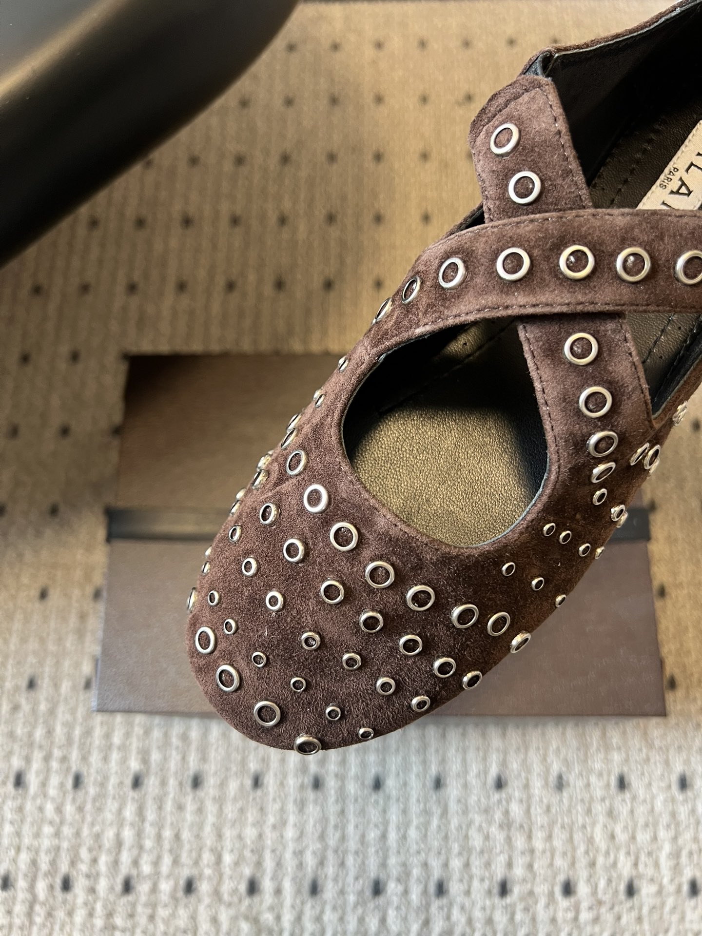 ALAÏ* 26ss 早春新款平底圆形镂空交叉绑带玛丽珍鞋单鞋鞋面采用镂空设计，形成密集的圆形孔洞纹理，