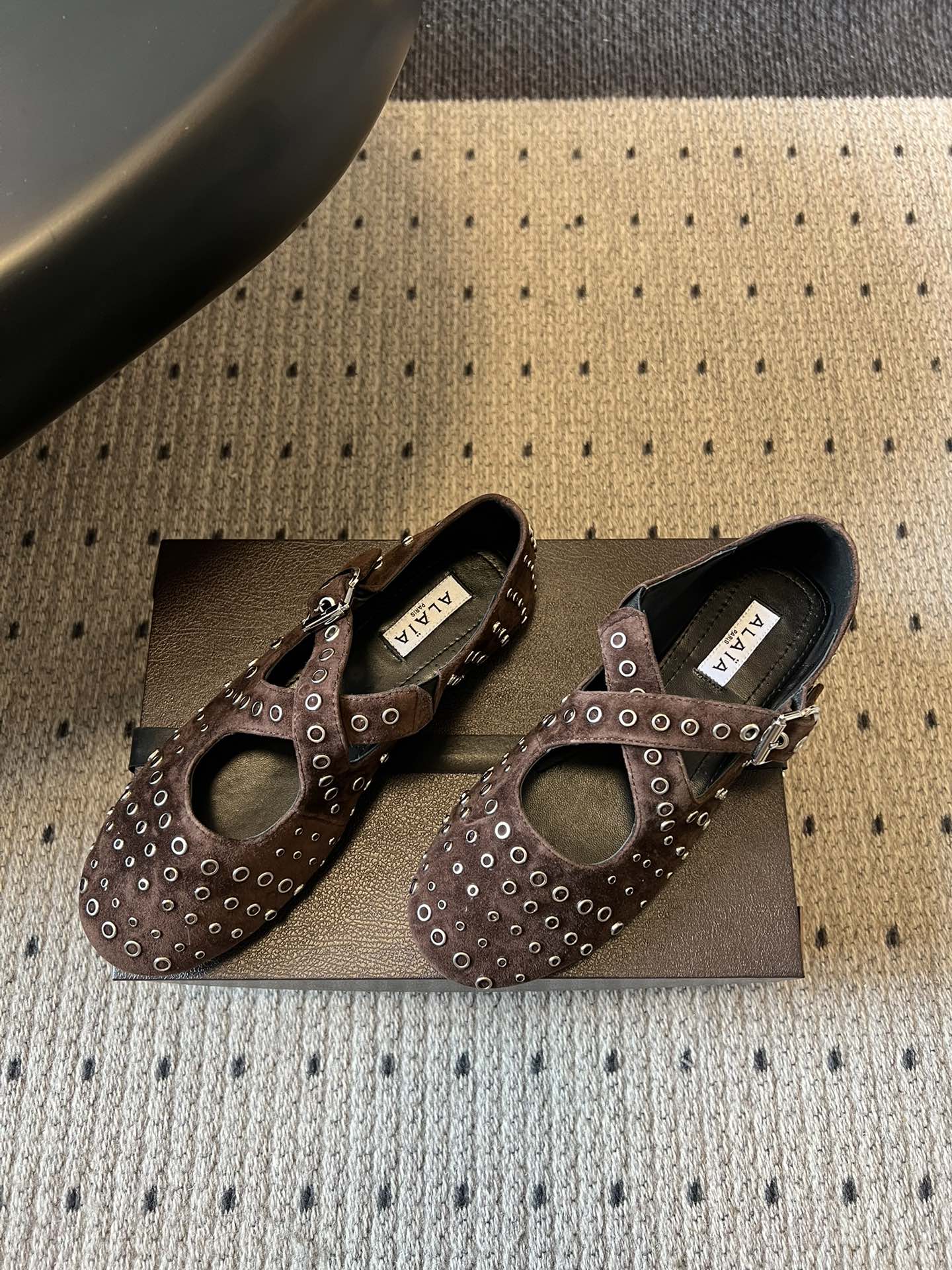 ALAÏ* 26ss 早春新款平底圆形镂空交叉绑带玛丽珍鞋单鞋鞋面采用镂空设计，形成密集的圆形孔洞纹理，