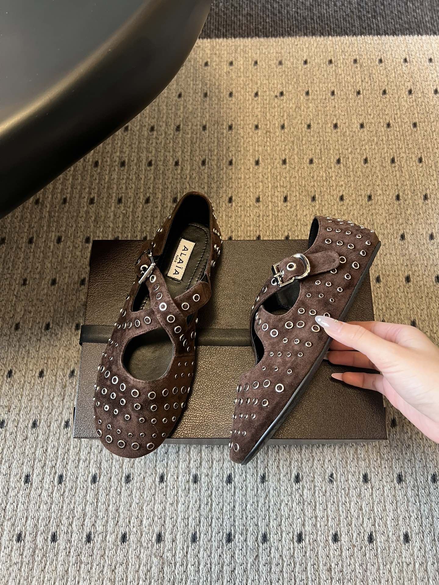 ALAÏ* 26ss 早春新款平底圆形镂空交叉绑带玛丽珍鞋单鞋鞋面采用镂空设计，形成密集的圆形孔洞纹理，