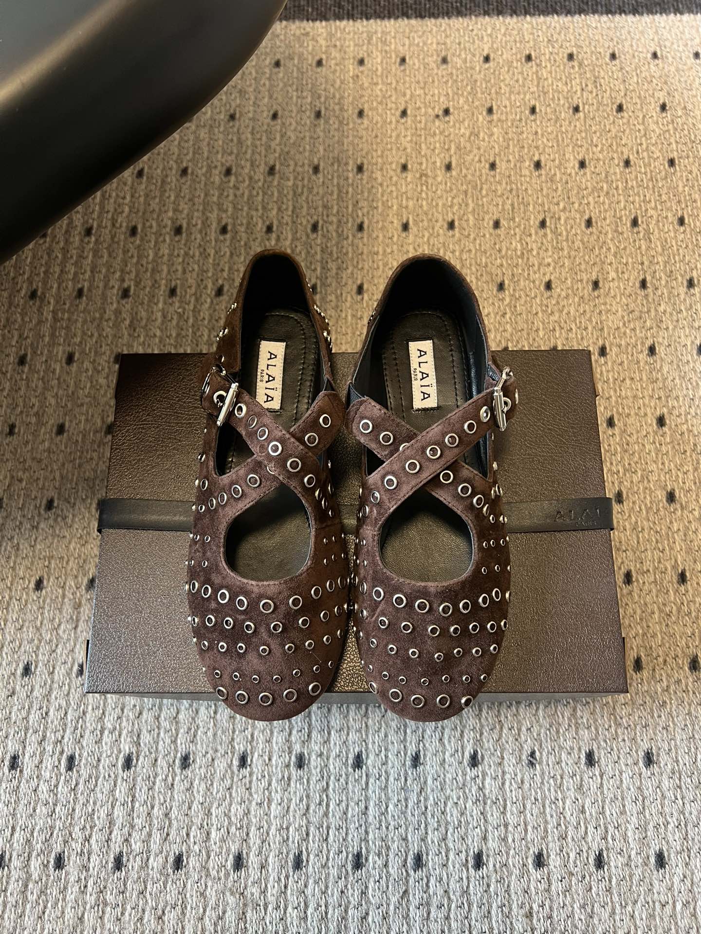 ALAÏ* 26ss 早春新款平底圆形镂空交叉绑带玛丽珍鞋单鞋鞋面采用镂空设计，形成密集的圆形孔洞纹理，