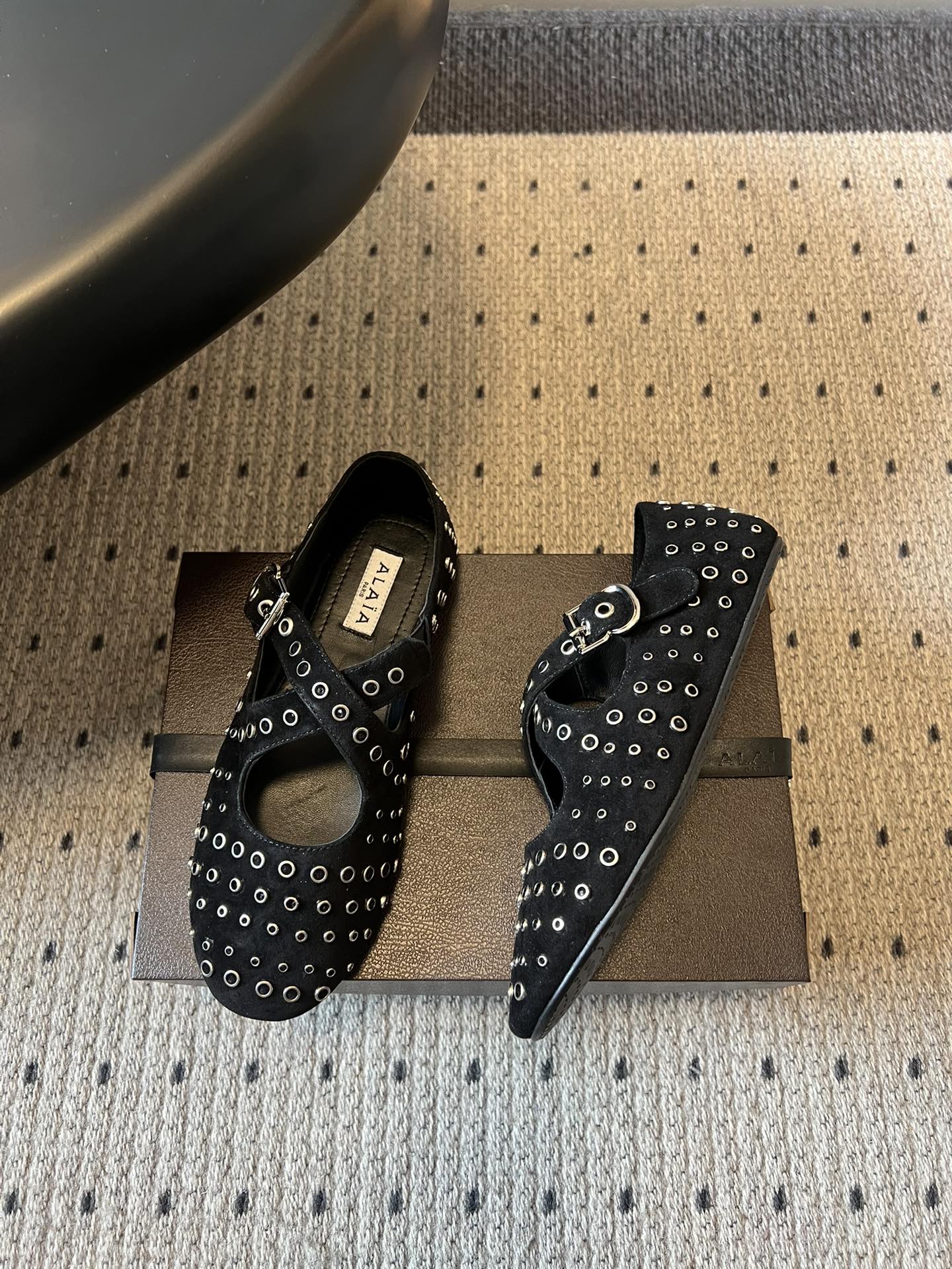 ALAÏ* 26ss 早春新款平底圆形镂空交叉绑带玛丽珍鞋单鞋鞋面采用镂空设计，形成密集的圆形孔洞纹理，