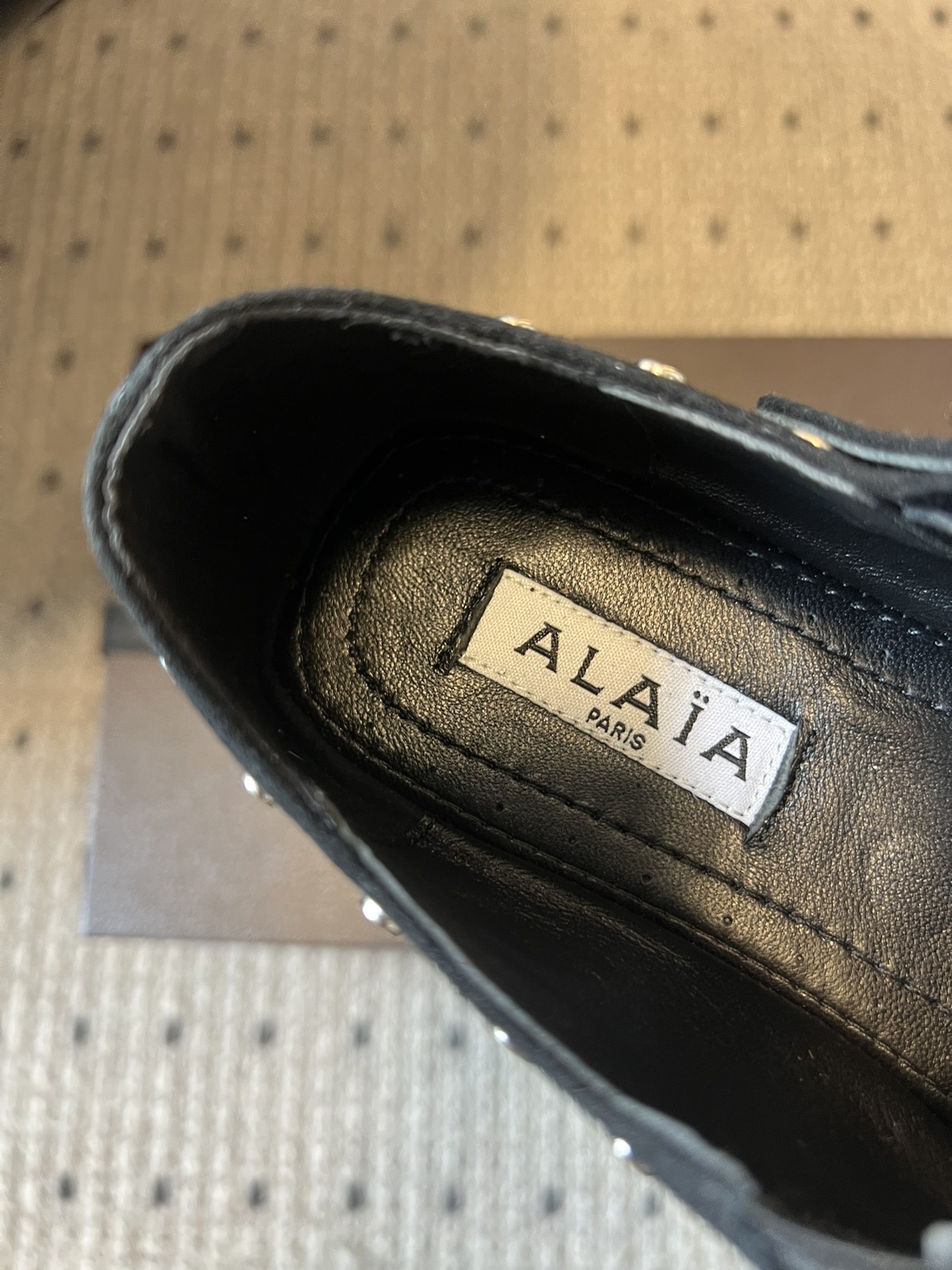 ALAÏ* 26ss 早春新款平底圆形镂空交叉绑带玛丽珍鞋单鞋鞋面采用镂空设计，形成密集的圆形孔洞纹理，