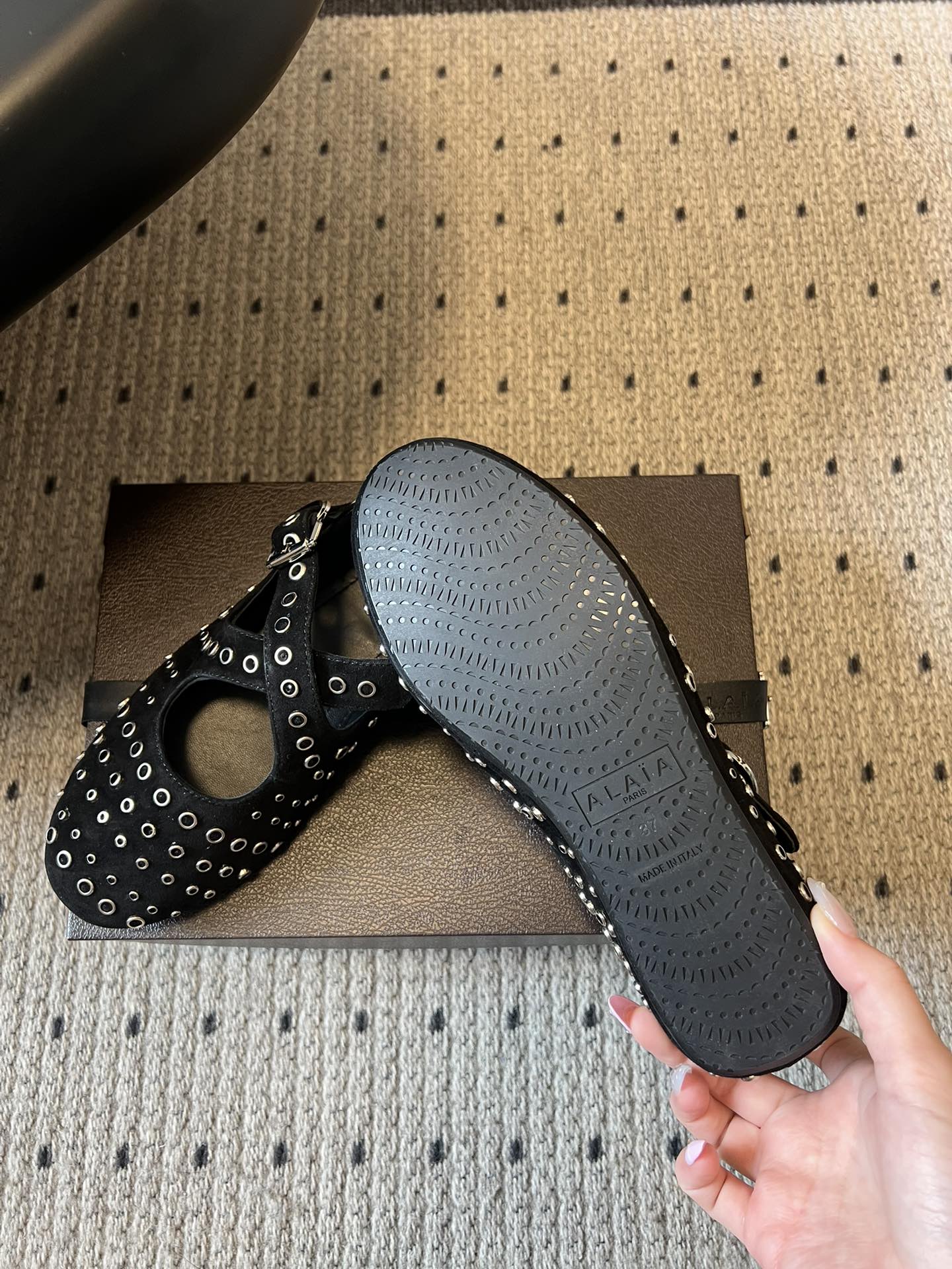 ALAÏ* 26ss 早春新款平底圆形镂空交叉绑带玛丽珍鞋单鞋鞋面采用镂空设计，形成密集的圆形孔洞纹理，