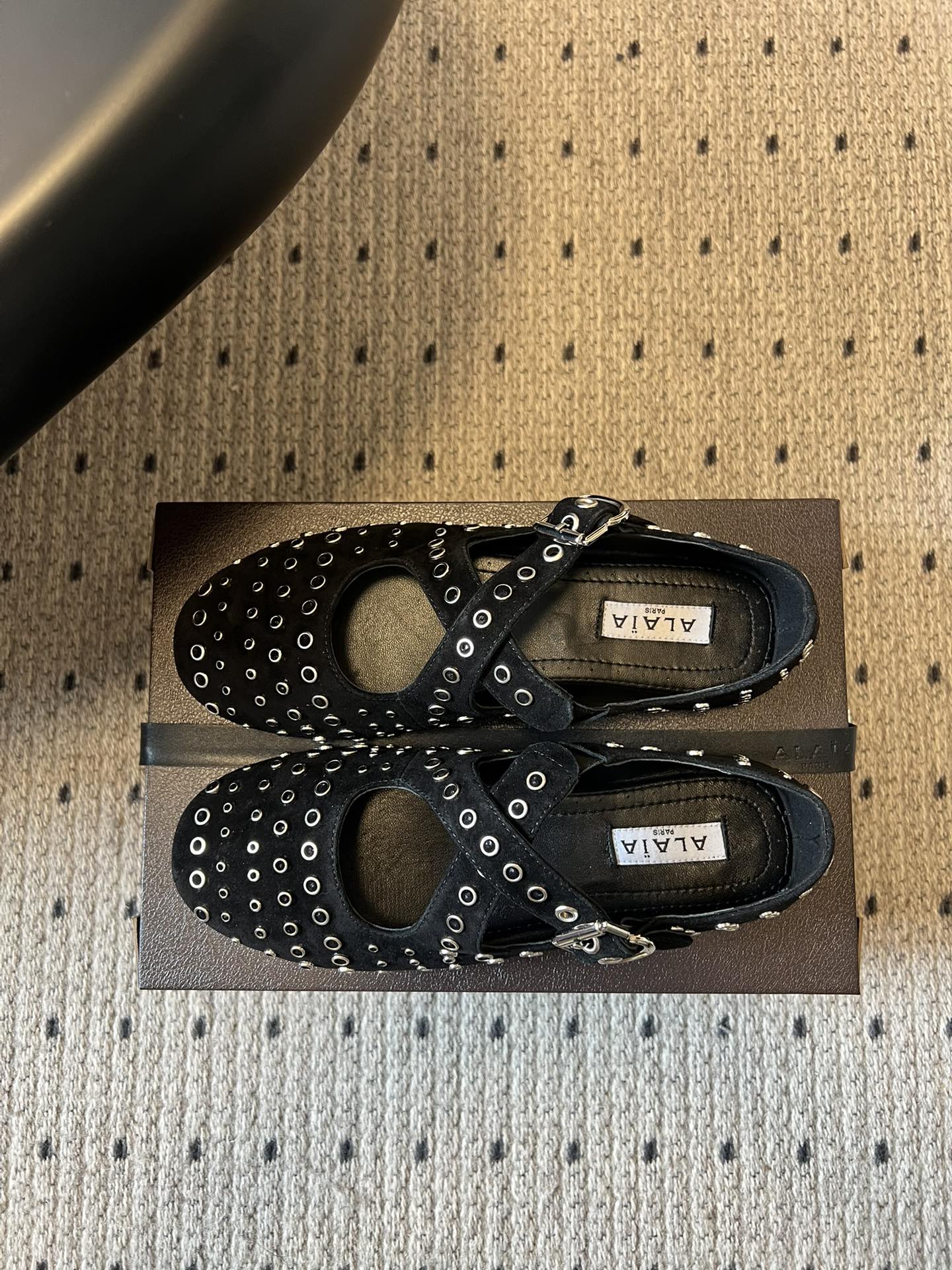 ALAÏ* 26ss 早春新款平底圆形镂空交叉绑带玛丽珍鞋单鞋鞋面采用镂空设计，形成密集的圆形孔洞纹理，
