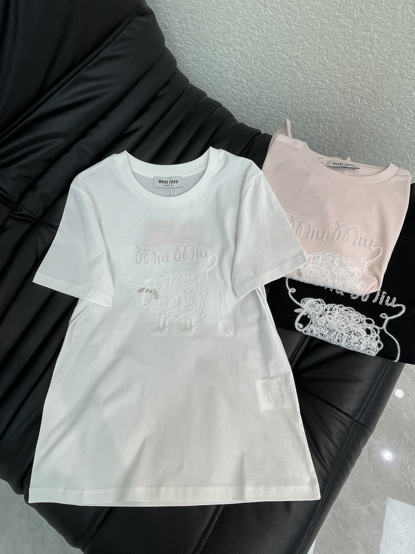 NO:717634,Miumi*26 new spring and summer beaded embroidered round neck short-sleeved T-shirt. Customized YB mercerized cotton material, breathable and comfortable, full of texture, slim embroidered T-shirt cut, white and pink are gentle and sweet, black and white are high-end fashion, exquisite beaded letters and three-dimensional embroidery of little sheep on the chest.  Breaking the monotony of solid colors, the delicate embroidery fully demonstrates the brand's craftsmanship. The 100% cotton fabric is soft and elastic and skin-friendly, and the slim fit makes it look slimmer. It is high-end when worn alone or layered with a jacket to create a layered look. It is a universal item that is indispensable in the wardrobe all year round. SML,, miumiu, jackets  & coats,T-shirt,tees,t-shirt,19860909Miumi*26春夏新款钉珠刺绣圆领短袖T恤.定制YB丝光全棉材质,透气舒适,质感十足,修身刺绣T恤剪裁,白配粉温柔清甜,黑配白高级时尚,胸口精致的订珠字母和小绵羊立体刺绣,打破纯色单调,细腻的绣工尽显品牌工艺.全棉面料软弹亲肤,修身版型显瘦气质,单穿高级,叠穿外套更显层次,是衣橱里一年四季都少不了的万能单品.SML,,miumiu,jackets & coats,T-shirt,tees，t-shirt,,Women's clothing