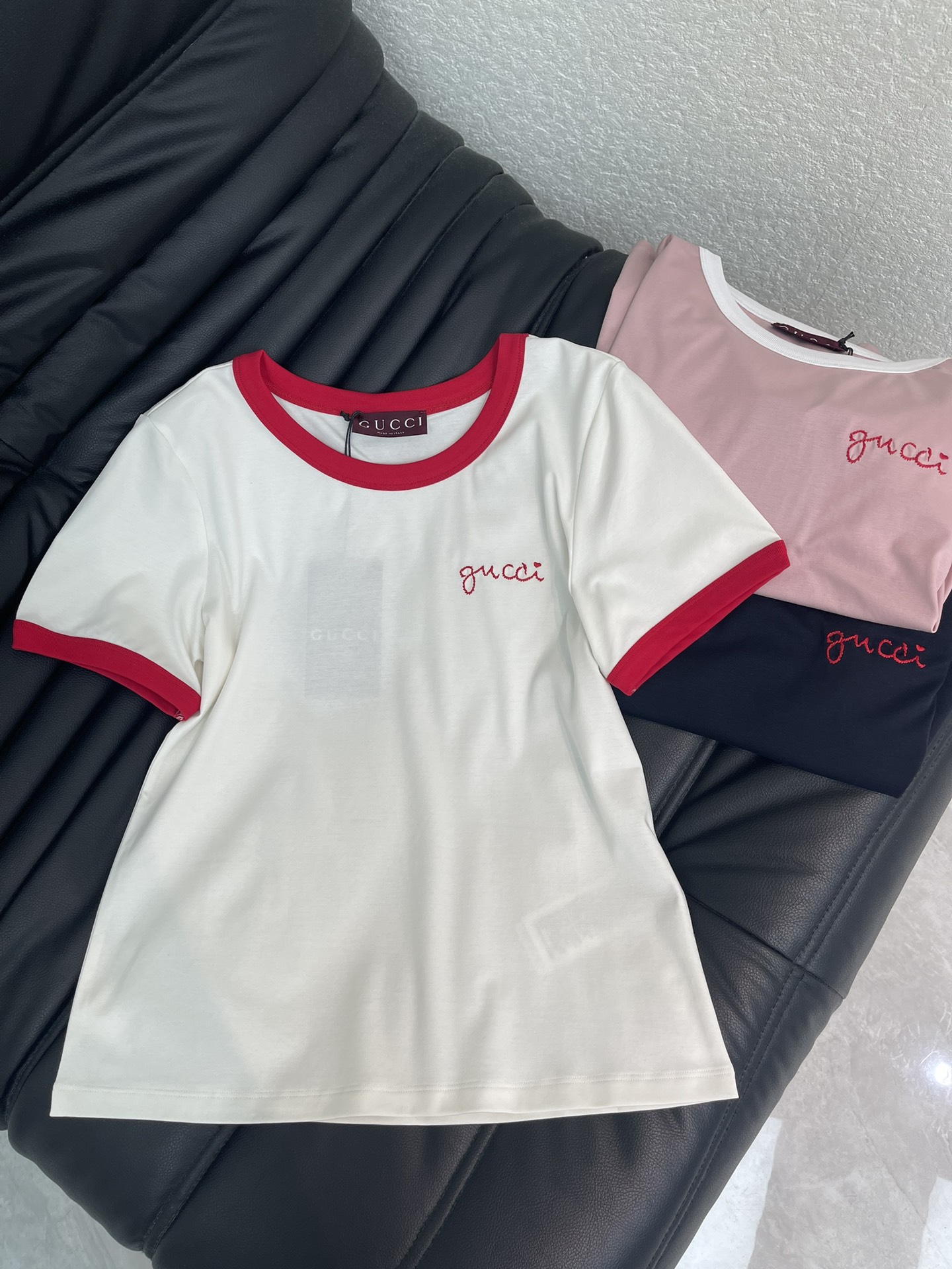 NO:717330,Gucc*26 new spring and summer contrasting color round neck short-sleeved T-shirt with letter logo. Customized YB mercerized cotton material, soft and skin-friendly, comfortable and stylish, regular short-sleeved shirt style, collar and cuffs echoing the contrasting threads, white, pink, black  Colors are optional. The soft and waxy cotton fabric is skin-friendly and breathable. The basic version is not flattering on the body shape. Wearing it alone gives a casual and lazy girlish look. Layering it with a knitted cardigan or jacket can unlock rich layers of outfits, reflect the brand tone, and be stylish and age-reducing. SML  A,,gucci,jackets & coats,T-shirt,tees,t-shirt,19860909Gucc*26春夏新款撞色圆领字母徽标短袖T恤.定制YB丝光全棉材质,柔软亲肤,舒适有型,常规短袖恤版型,领口和袖口呼应以螺纹撞色,白色,粉色、黑色三色可选.软糯的棉质面料亲肤又透气,基础版型不挑身形,单穿是随性的慵懒少女感,叠穿针织开衫或外套,又能解锁层次丰富的穿搭,体现品牌基调,洋气减龄.SML A,,gucci,jackets & coats,T-shirt,tees，t-shirt,,Women's clothing