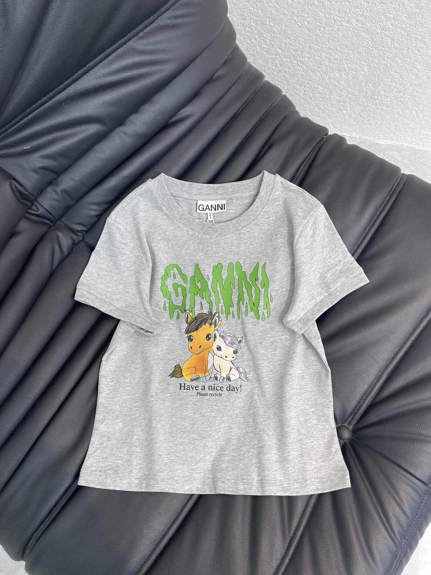 NO:730548,GANN*26 New Year of the Horse limited-edition short-sleeved T-shirt, made of gray cotton fabric, with two cartoon ponies in green GANNI words on the front, paired with the slogan 'Havea nice day!', full of childlike fun. Loose fit, comfortable and breathable, perfect for daily casual wear! As a limited edition, it has high collection value. Don't miss it if you like unique designs!  SML,,T-shirt,tees,t-shirt,19860909GANN*26新品马年限定短袖T恤,灰色棉质面料,正面有两只卡通小马绿色GANNI字样,搭配'Havea nice day!'标语,童趣满满 .宽松版型,舒适透气,日常休闲穿搭超合适!作为限定款,收藏价值高,喜欢独特设计的姐妹别错过啦！SML,,T-shirt,tees，t-shirt,,Women's clothing