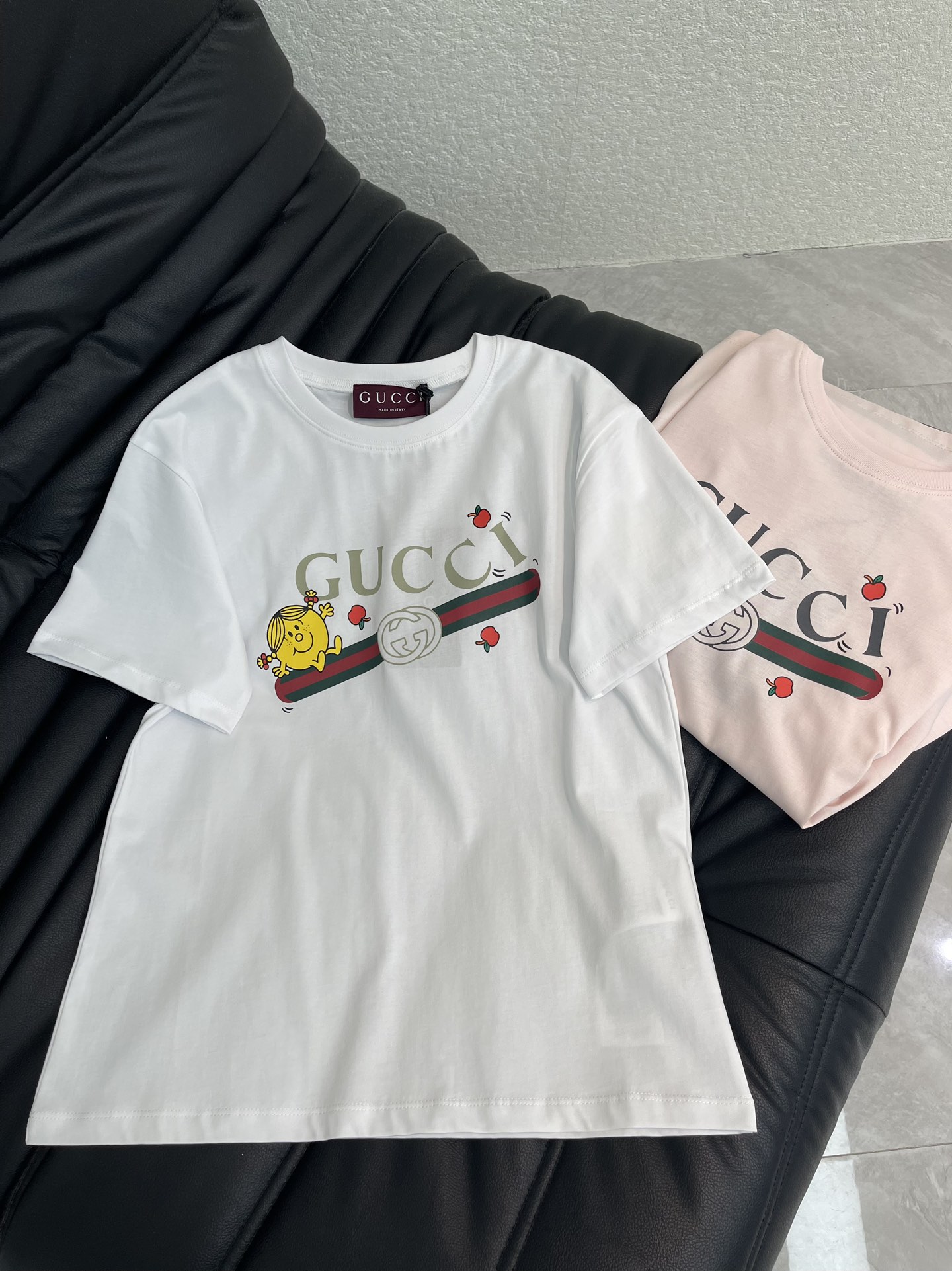 NO:731325,Gucc*26 new spring and summer childlike printed round neck short-sleeved T-shirt | Exclusively developed by yb!  High quality production!  The classic red and green webbing has soft and cute minions bouncing around, embellished with a few playful little apples, and the retro logo has also become lively. The soft and fufu pure cotton fabric upper body does not want to be taken off, and the round neck version is not flattering on the figure. It is refreshing and sweet when paired with jeans. When paired with a skirt, it instantly transforms into a retro girl. Wear it out in early spring, and it will turn heads all over SML AA, gucci, skirts, jeans, T-shirt, tees, t-shirt,19860909Gucc*26春夏新款童趣印花圆领短袖T恤丨独家yb开发！高版出品！经典红绿织带上蹦跳着软萌小黄人,点缀几颗俏皮小苹果,复古logo也跟着变得鲜活起来.软fufu的纯棉面料上身就不想脱,圆领版型不挑身材,配牛仔裤是清爽甜妹,搭半裙又秒变复古少女,早春穿它出门,回头率直接拉满SML AA,,gucci,skirts,jeans,T-shirt,tees，t-shirt,,Women's clothing