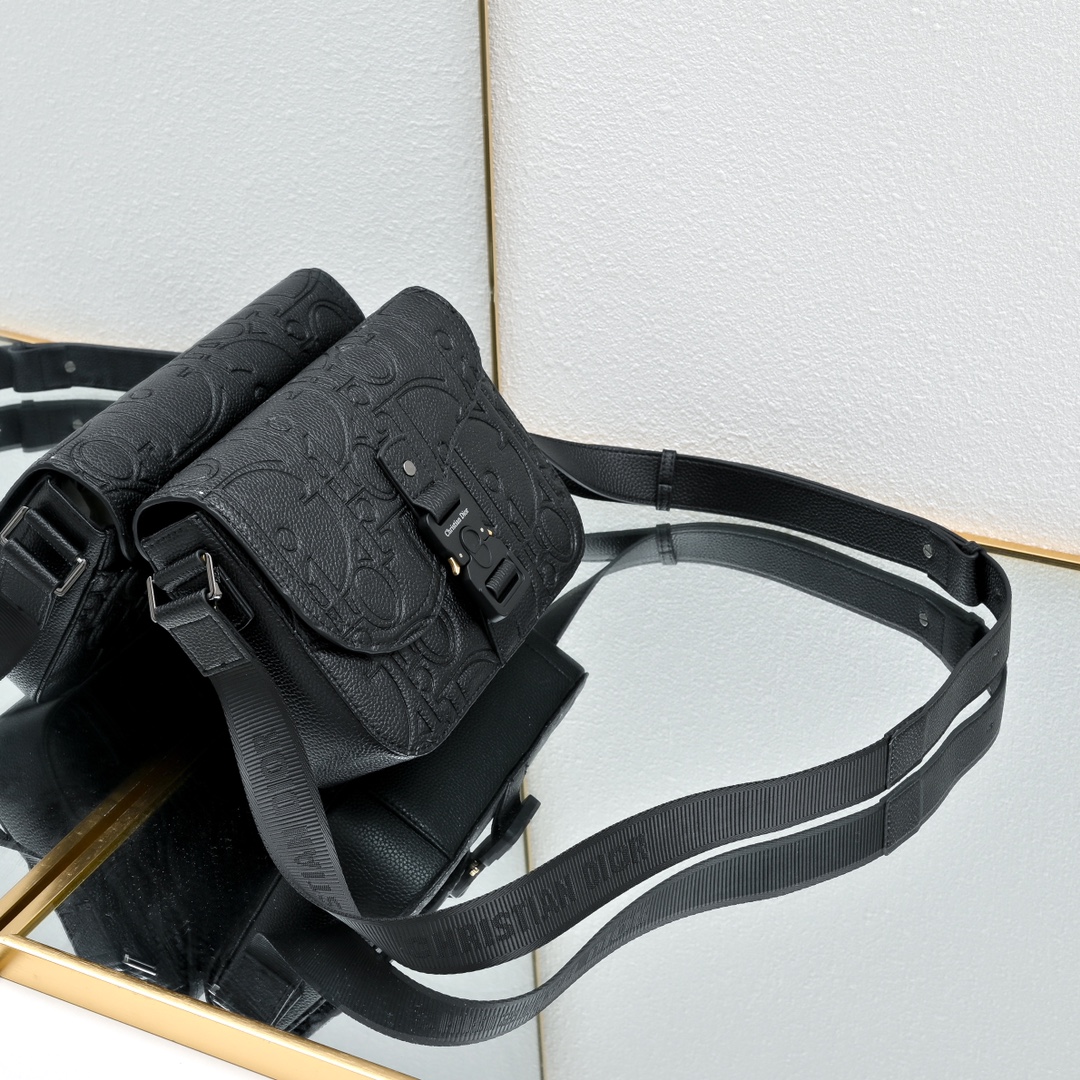 马鞍插扣压花信使包精巧时尚。采用米色和黑色 Oblique 印花面料精心制作，饰以黑色粒面牛皮革翻盖和“