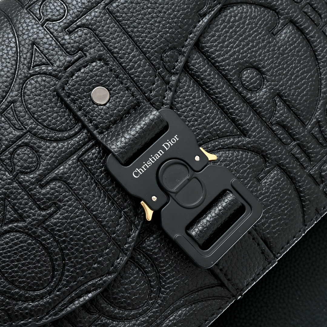 马鞍插扣压花信使包精巧时尚。采用米色和黑色 Oblique 印花面料精心制作，饰以黑色粒面牛皮革翻盖和“