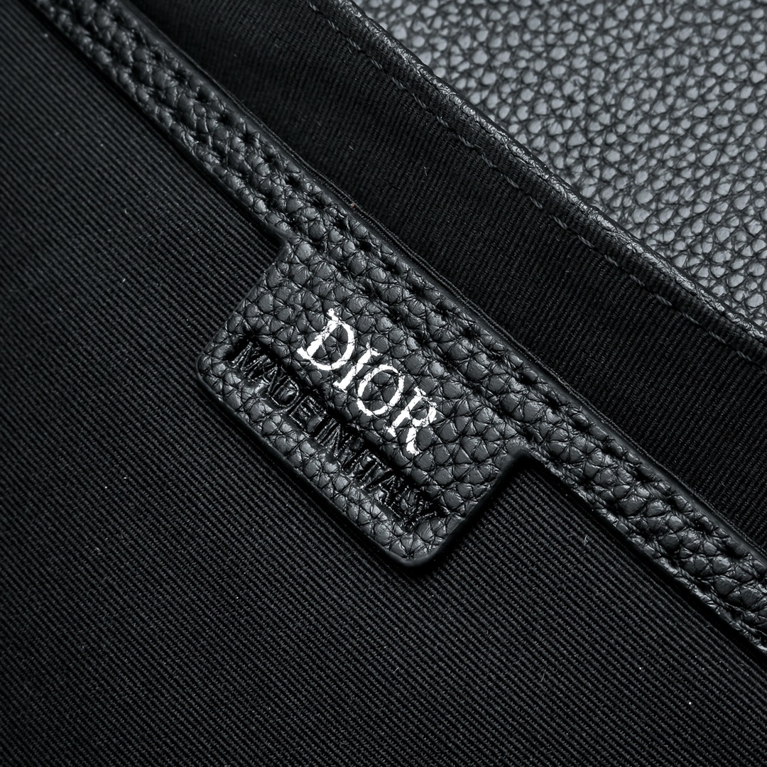 马鞍插扣压花信使包精巧时尚。采用米色和黑色 Oblique 印花面料精心制作，饰以黑色粒面牛皮革翻盖和“