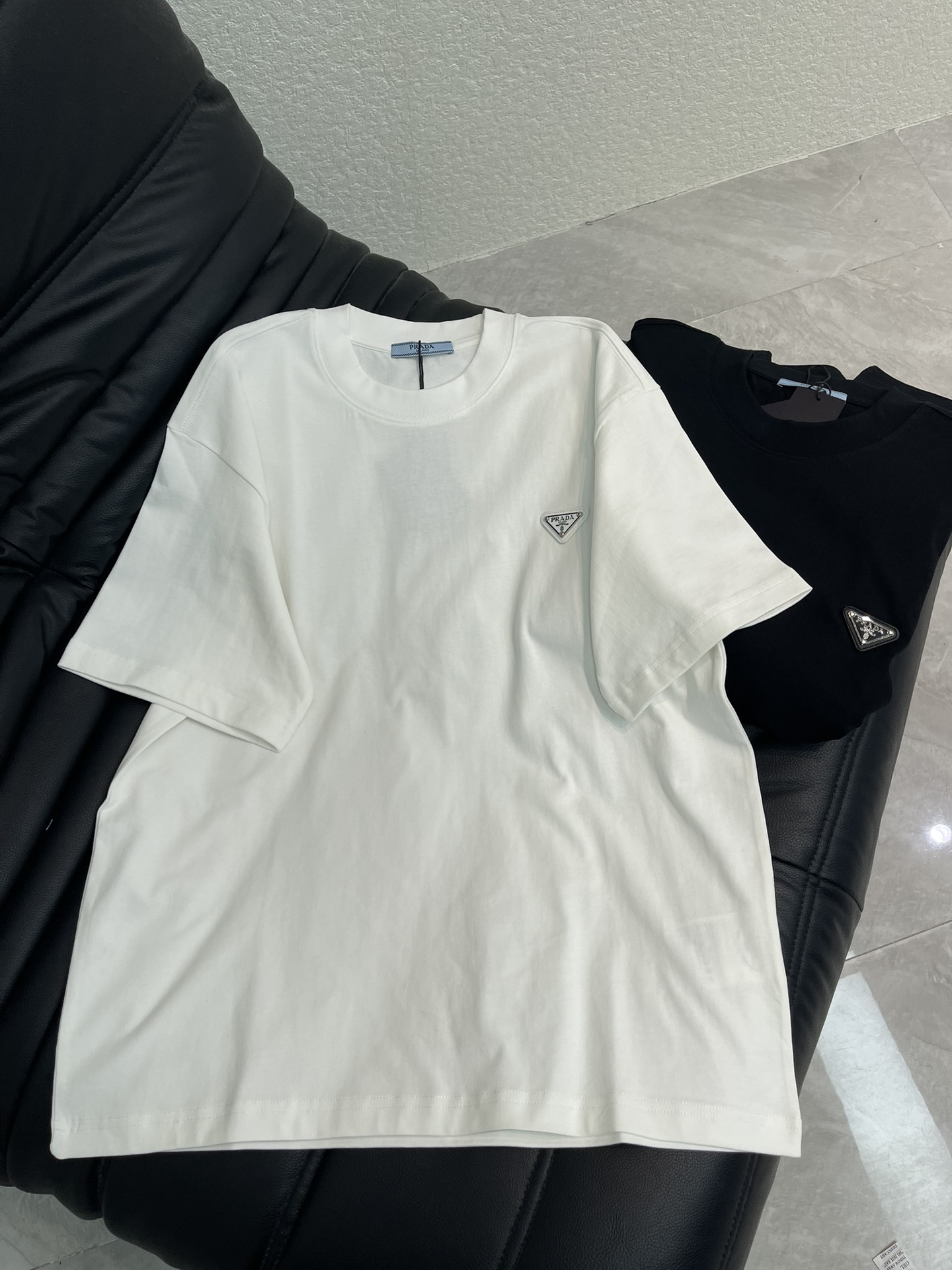 NO:734597,Prad*26 new inverted triangle iron logo round neck short-sleeved T-shirt. Made of high-gram heavy-wash pure cotton fabric, pure cotton is breathable, very refreshing and comfortable for daily wear. The rib knitting on the neckline is smooth and tight, and the neckline will not be skewed when you toss it around. It has a loose fit and you will find that it looks really good on the upper body. The overall design is simple and neat, and it is super versatile for daily wear!  Pair it casually with one to give you a youthful look. A round neck will make your outfit go crazy. It is a fashionable item that can never go wrong!  Same style for men and women!  S-XL,,prada,T-shirt,tees,t-shirt,19860909Prad*26新款倒三角铁标圆领短袖T恤.高克重洗水纯棉质面料,纯棉透气,日常穿着非常清爽穿感舒适,领口的罗纹针织平整紧密,随意折腾都不会领口歪斜,宽松版型,上身你就会发现真的好好看,整体极简利落,超级日常百搭！随随便便搭配一条就是青春的样子,一件圆领就能为你的穿搭疯狂,绝不会出错的时髦单品！男女同款！S-XL,,prada,T-shirt,tees，t-shirt,,Women's clothing