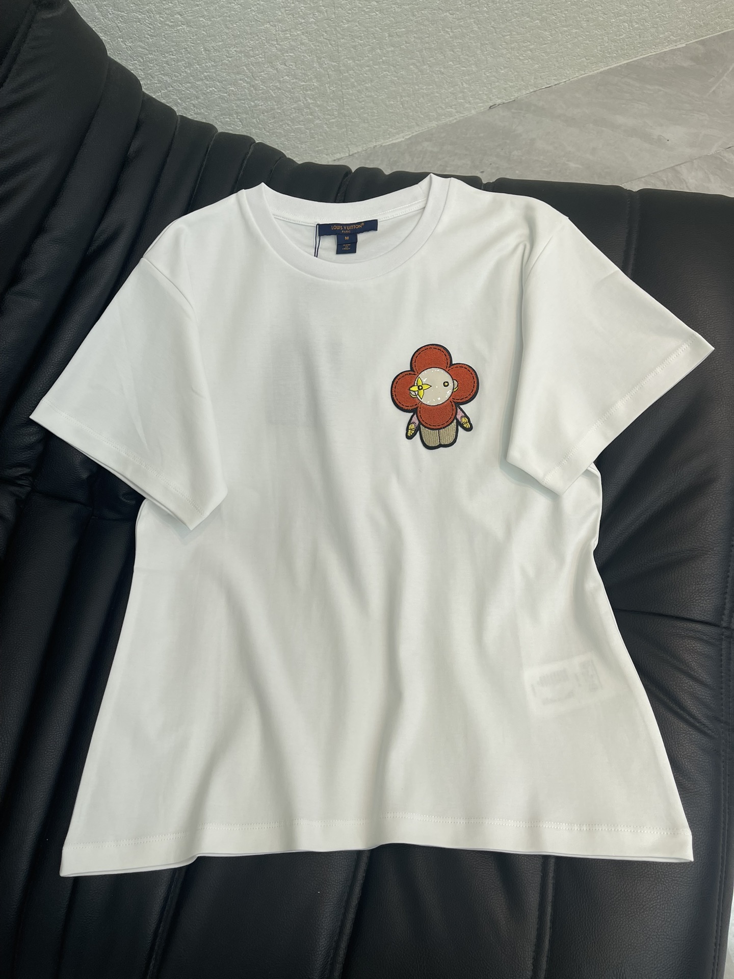 NO:734644,Louis Vuitt*n 26 new spring and summer sunflower toothbrush embroidered cartoon short-sleeved round neck T-shirt!  The pure background color is used to outline the smart cartoon pattern, and the three-dimensional toothbrush embroidery process makes the pattern appear on the body, with a full and layered touch. The high-count mercerized cotton fabric is selected to create a soft and crisp wearing experience. The classic round neck adapts to various body shapes, and the neat tailoring unlocks a variety of spring outfits. Incorporate childlike ingenuity into daily life, blending classic luxury with fresh vitality, becoming a versatile finishing touch in the early spring wardrobe. SML,, louis  vuitton,T-shirt,tees,t-shirt,19860909Louis Vuitt*n 26春夏新款太阳花牙刷绣卡通短袖圆领T恤！以纯净底色勾勒灵动卡通纹样,立体牙刷绣工艺让图案跃然衣身,触感饱满更具层次.甄选高支丝光棉面料打造柔软挺括的穿着体验,经典圆领适配各种身形,利落剪裁解锁春日多元穿搭.将童趣巧思融入日常,让经典奢华与清新活力相融,成为早春衣橱里的百搭点睛之选.SML,,louis vuitton,T-shirt,tees，t-shirt,,Women's clothing