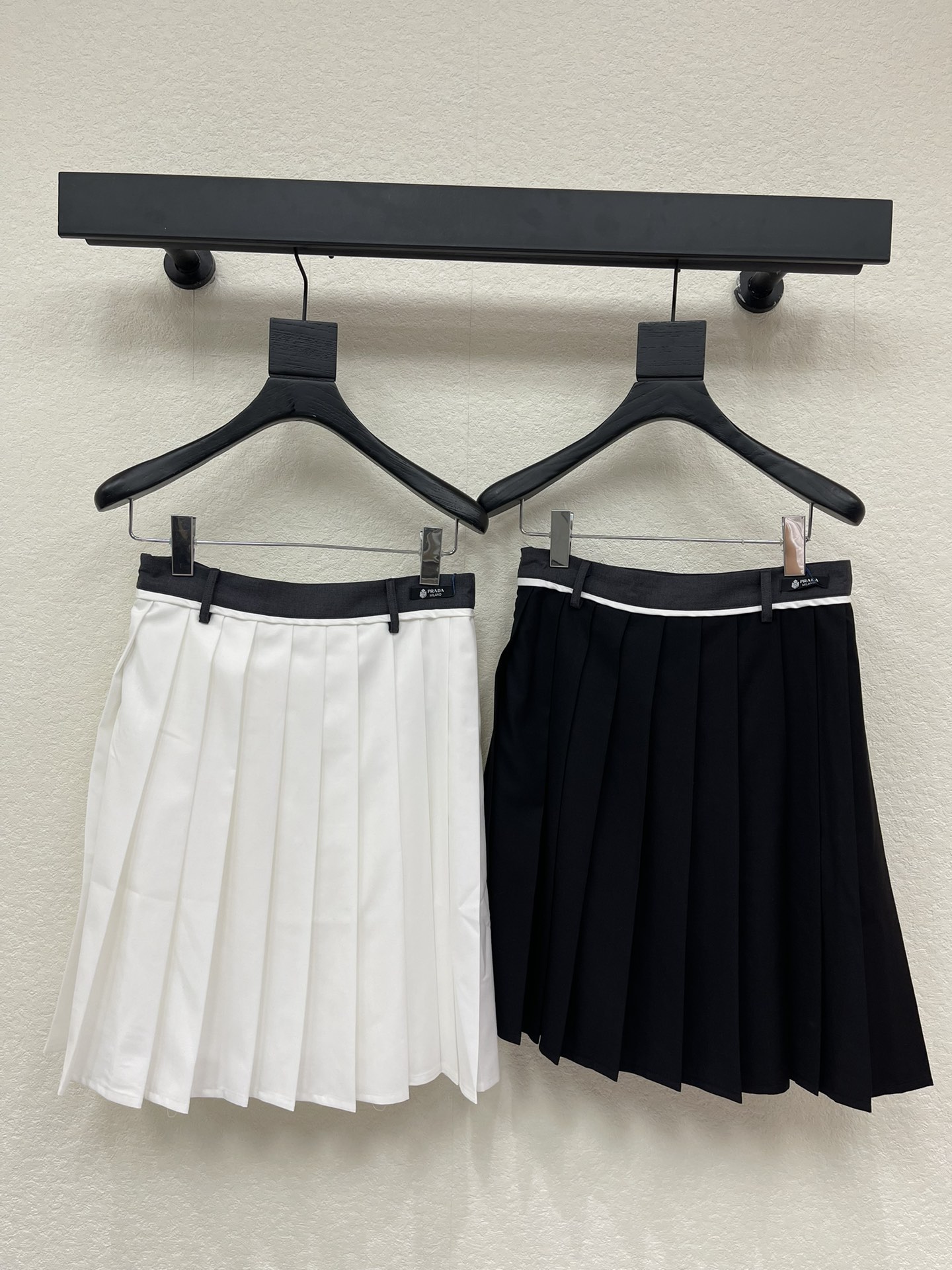 NO:734634,Prad*26 new spring and summer high-waisted pleated skirt, with a classic academic style design, embellished with white stripes on the waistband, and the brand's iconic label, with a high-end texture and a youthful atmosphere. The skirt is made of crisp fabric, with even pleats and a moderate length, which can modify the shape of the legs and is versatile. Whether it is daily commuting, campus-style wear, or layering in autumn and winter, it can be easily controlled and is an indispensable 'universal item in the wardrobe, SML, prada, skirts,19860909Prad*26春夏新品高腰百褶裙半身裙,经典学院风设计,腰头饰有白色条纹点缀,搭配品牌标志性标签,质感高级又不失青春气息.裙身采用挺括面料,褶皱均匀,长度适中,既能修饰腿型,又百搭实穿.无论是日常通勤,校园风穿搭,还是秋冬叠穿,它都能轻松驾驭,是衣橱里不可或缺的'万能单品,SML,,prada,skirts,,Women's clothing