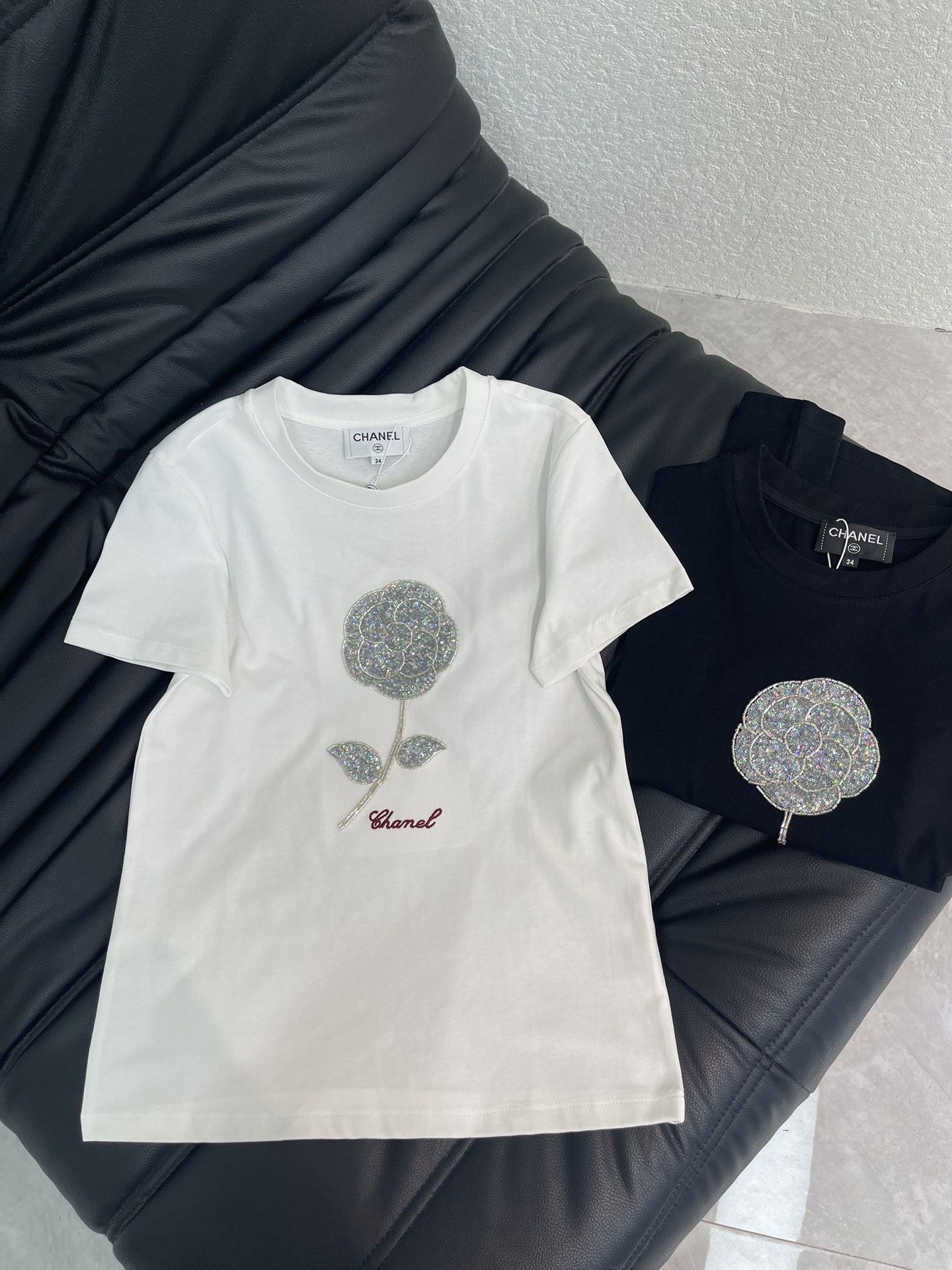 NO:736760,CHANE* 2026 early spring latest series!  Right shoulder beaded camellia short-sleeved T-shirt!  Customized mercerized cotton material, breathable and comfortable, full of texture, beaded and sequined T-shirt cut, black and white basic color matching high fashion, exquisite camellia beading on the chest and artistic floral letter logo embroidery, breaking the monotony of solid colors, delicate embroidery work shows the brand craftsmanship. The cotton fabric is soft and elastic, skin-friendly, and the slim fit makes you look slimmer. It is high-end when worn alone, or when layered with a jacket, it will look more layered. It is an all-purpose item that is indispensable in the wardrobe all year round!  SML,,chanel,jackets & coats,T-shirt,tees,t-shirt,19860909CHANE* 2026早春最新系列！正肩钉珠山茶花短袖T恤！定制丝光全棉材质,透气舒适,质感十足,钉珠亮片T恤剪裁,黑白基础配色高级时尚,胸口精致的山茶花订珠和艺术花体字母徽标刺绣,打破纯色单调,细腻的绣工尽显品牌工艺.全棉面料软弹亲肤,修身版型显瘦气质,单穿高级,叠穿外套更显层次,是衣橱里一年四季都少不了的万能单品！SML,,chanel,jackets & coats,T-shirt,tees，t-shirt,,Women's clothing