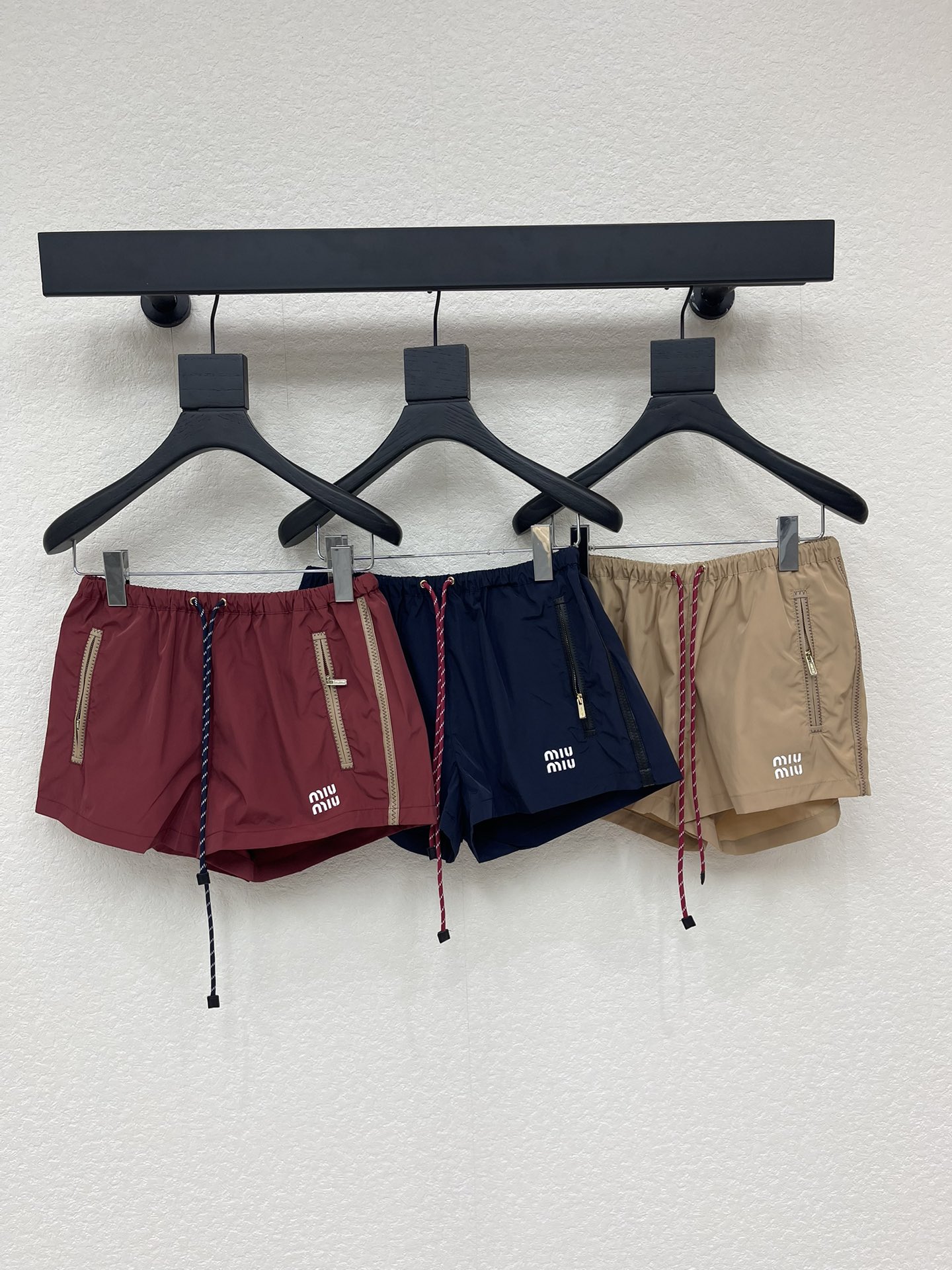 NO:738987,Miumi*26 new early spring nylon shorts are a popular representative item of 'sweet and cool style'. They are made of lightweight waterproof nylon fabric, with silver zipper pockets on both sides and a drawstring waistband. The lower left corner is embellished with the brand's iconic letter patch embroidery. The overall design has both a sporty and high-end feel. The burgundy color is white and eye-catching. Whether it is paired with a basic style or a layered look, it can easily create a fashionable focus!  SML,,miumiu,shorts,19860909Miumi*26早春新款尼龙短裤,是备受追捧的“甜酷风”代表单品,采用轻盈防水尼龙面料,搭配两侧银色拉链口袋和抽绳腰头,左下角点缀品牌标志性字母贴布刺绣,整体设计兼具运动感与高级感,酒红色调显白又吸睛,无论是搭配基础款还是叠穿造型,都能轻松打造时髦焦点！SML,,miumiu,shorts,,Women's clothing