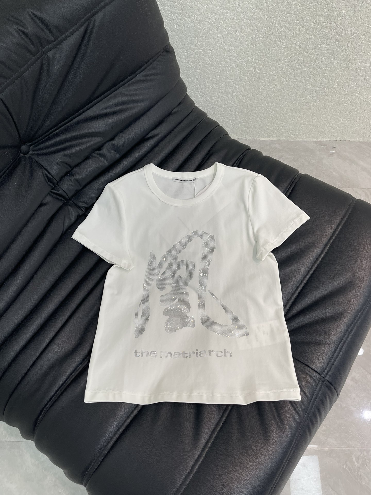 NO:740445,Alexanderwan*26 spring and summer new product 'Feng' heavy industry hot-drilled short-sleeved T-shirt, pure white background + hot-drilled 'phoenix' word, super recognizable 'thematriarch' word below, full aura, full of matriarch atmosphere. A basic white T can also be worn with personality, it looks great with jeans or work skirts, and it is easy to attract attention when going out in daily life. SML A,,skirts,jeans,T-shirt,tees,t-shirt,19860909Alexanderwan*26春夏新品'凤'重工烫钻短袖T恤,纯白底色+烫钻'凤'字,超有辨识度下方'thematriarch'字样,气场全开,女族长氛围感拉满.基础白T也能穿出个性,随便搭牛仔裤or工装裙都很出彩,日常出街轻松吸睛.SML A,,skirts,jeans,T-shirt,tees，t-shirt,,Women's clothing