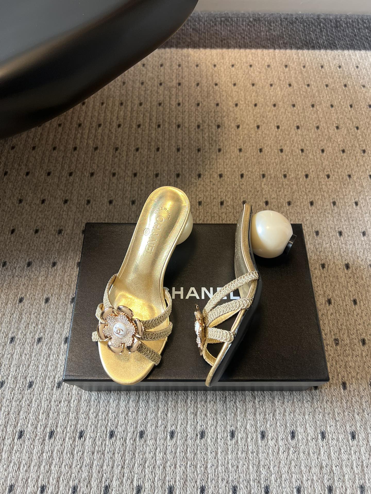 Chane*26SS春夏新款珍珠跟山茶花凉拖设计上藏满品牌标志性的浪漫巧思，经典的山茶花饰扣搭配交叉细带