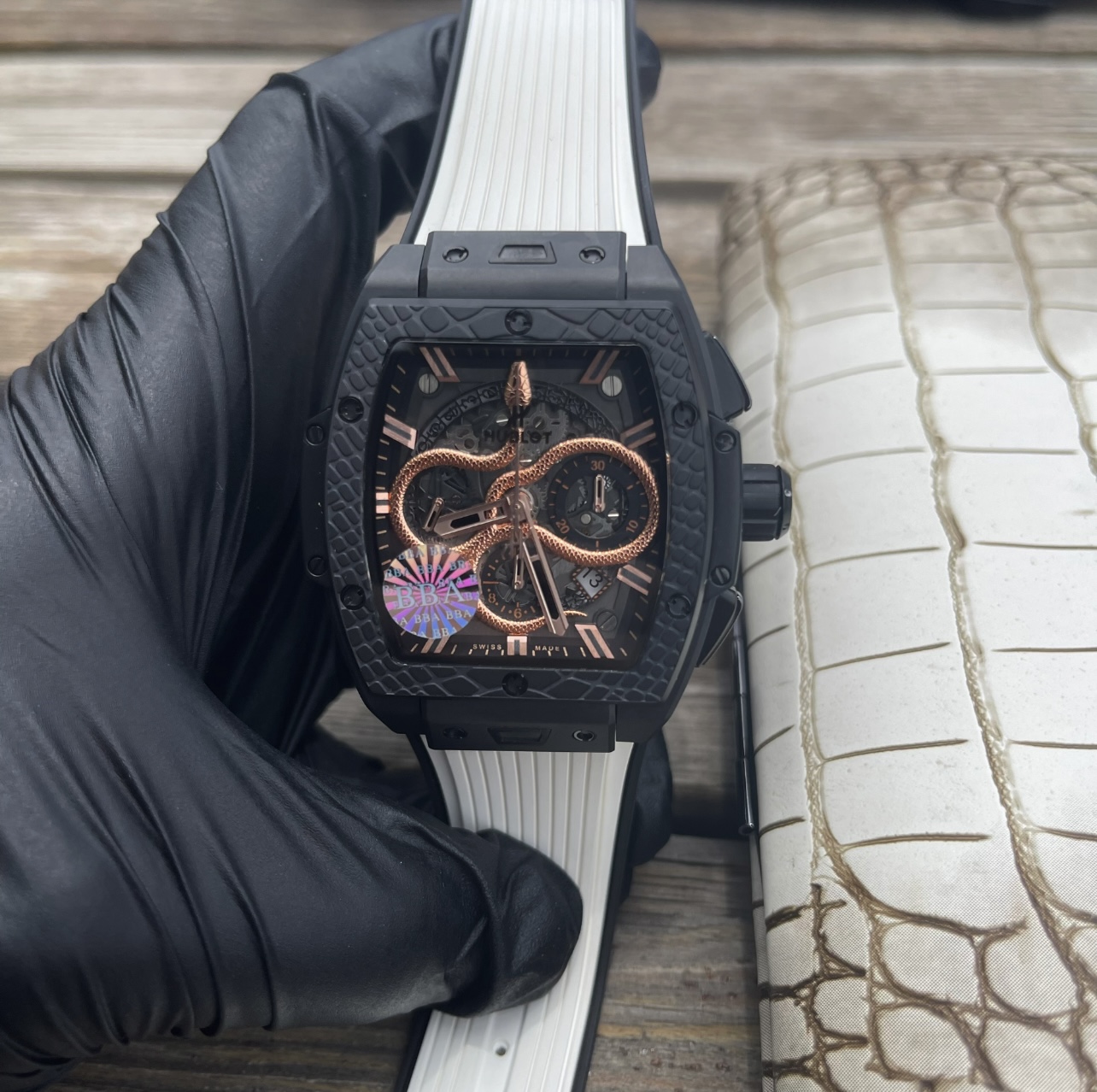 NO:947389,Produced by BBA [Snake Presents Auspiciousness· Hublot Hublot Zodiac Special Edition] ** In order to pay tribute to the Lunar Year of the Snake, Hublot Hublot has created this high-end mechanical watch that combines oriental auspiciousness and Swiss precision. In the center of the dial is a hand-carved three-dimensional snake, with distinct layers of scales, and the snake's head held high to express its agility. Internally equipped with **ETA  The movement** has been adjusted by a master and has 45 hours of power reserve and observatory-level accuracy. The 42mm** all-ceramic case** uses nano-polishing technology, with a light texture and 9-level Mohs hardness. **Natural rubber snake pattern strap** has built-in titanium alloy fasteners, which are comfortable to wear and have hidden edge. The world is limited to 88 pieces, each of which is engraved with an independent number. It is not only a testimony of exquisite watchmaking craftsmanship, but also a zodiac collection that collectors cannot miss.19860909BBA出品【灵蛇献瑞·恒宝宇舶生肖特别款】**  为致敬农历蛇年,恒宝宇舶匠心打造这款集东方祥瑞与瑞士精工于一体的高端机械腕表.表盘中央以手工精雕立体灵蛇,鳞甲层次分明,蛇首昂扬吐信,尽显灵动之姿.内部搭载**ETA 机芯**,经大师调校,具备45小时动储与天文台级精度.42mm**全陶瓷表壳**采用纳米抛光技术,兼具轻盈质感与9级莫氏硬度.**天然橡胶蛇纹表带**内嵌钛合金扣件,佩戴舒适且暗藏锋芒.全球限量88枚,每一只均镌刻独立编号,既是精湛制表工艺的见证,更是藏家不容错过的生肖典藏.,,Watch