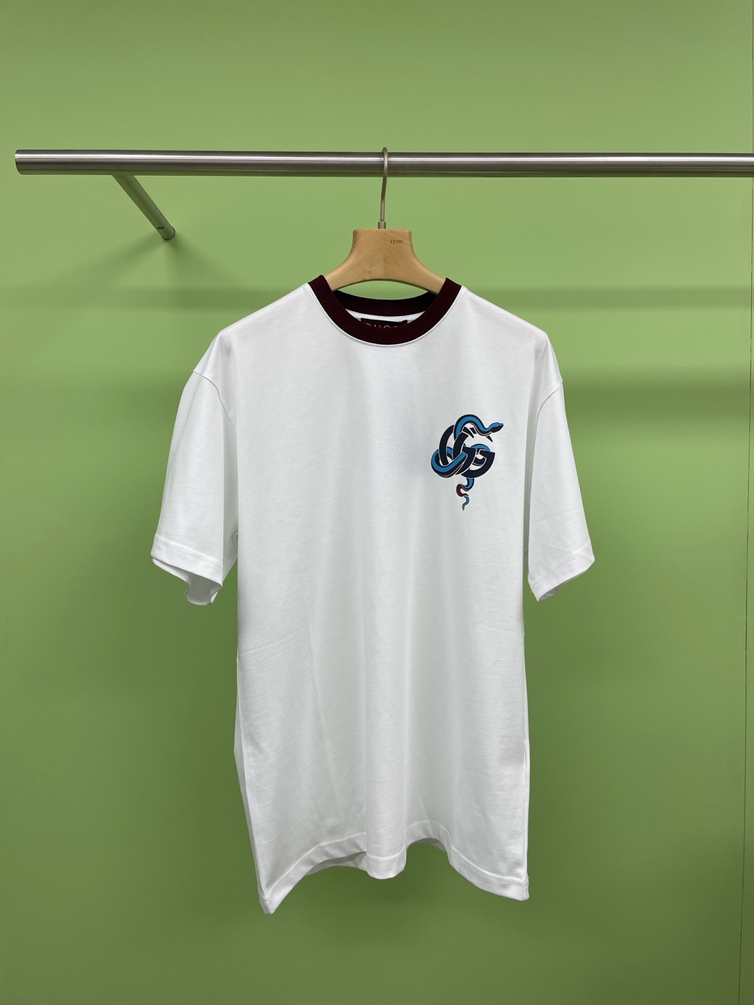 NO:295087,Gucci Year of Snake Printed Cotton T-shirt, white and navy blue, combined with exquisite tailoring, create classic and charming wardrobe items. This slim fit T-shirt is made of lightweight knitted cotton, cleverly blending with Gc logo and blue snake print. The red contrasting piping adds charm to the entire silhouette. The structure of the pure cotton fabric is plain, the fabric of the fabric is flat, the fabric surface is flat, the texture is tight, with good moisture absorption, breathability and comfort, and can maintain dryness and comfort. Due to its tight spinning process, it also has good wrinkle resistance and durability, suitable for long-term wear or use, and the printing process is  The special glue for special silicone oil cloth is used to print patterns on silicone oil-treated fabrics through specific printing technology, combining the softness of silicone oil and the high density of elastic glue, making the printed fabric both soft and elastic. At the same time, the printed pattern is clear and the colors are bright, perfectly integrating the essence of the zodiac sign of oriental culture with international fashion trends, adding a different style to the new year. Wearing it is not only a choice in clothing, but also a dialogue between culture and aesthetics, a close contact between the soul and nature. In the new year, let us go on this journey about the beauty and dreams of the Year of the Snake together.  Code number XS SML, gucci,tees, t-shirt,alexander wang19860909Gucci蛇年印花棉质T恤,白色与藏蓝蓝色巧妙撞色搭配,结合考究十足的剪裁,缔就经典且迷人的衣橱单品,这款修身版型T恤以轻质针织棉匠心打造,巧妙融入Gc标识和蓝蛇印花.红色撞色滚边令整个廓形更添魅力,纯棉质织物组织结构为平纹,面料的织物表面平整细腻,质地紧密,具有良好的吸湿透气性和舒适性,能够保持干爽舒适.由于其紧密的纺纱工艺,它也具有良好的抗皱性和耐久性,适合于长时间穿着或使用,印花工艺采用特制的硅油布专用胶浆,通过特定的印刷技术将图案印制到硅油处理过的面料上,结合了硅油的柔软性和弹力胶浆的高密度特性,使得印花后的面料既柔软又富有弹性,同时印花图案清晰、色彩亮丽,将东方文化的生肖精髓与国际时尚趋势完美融合,为新的一年增添了一份别样的风情,穿上它,不仅是一种服装上的选择,更是一次文化和审美的对话,一次心灵与自然界的亲密接触,在新的一年里,让我们共赴这场关于蛇年美丽与梦想的旅行. 码数XS SML,,gucci,tees，t-shirt,alexander wang,Women's clothing