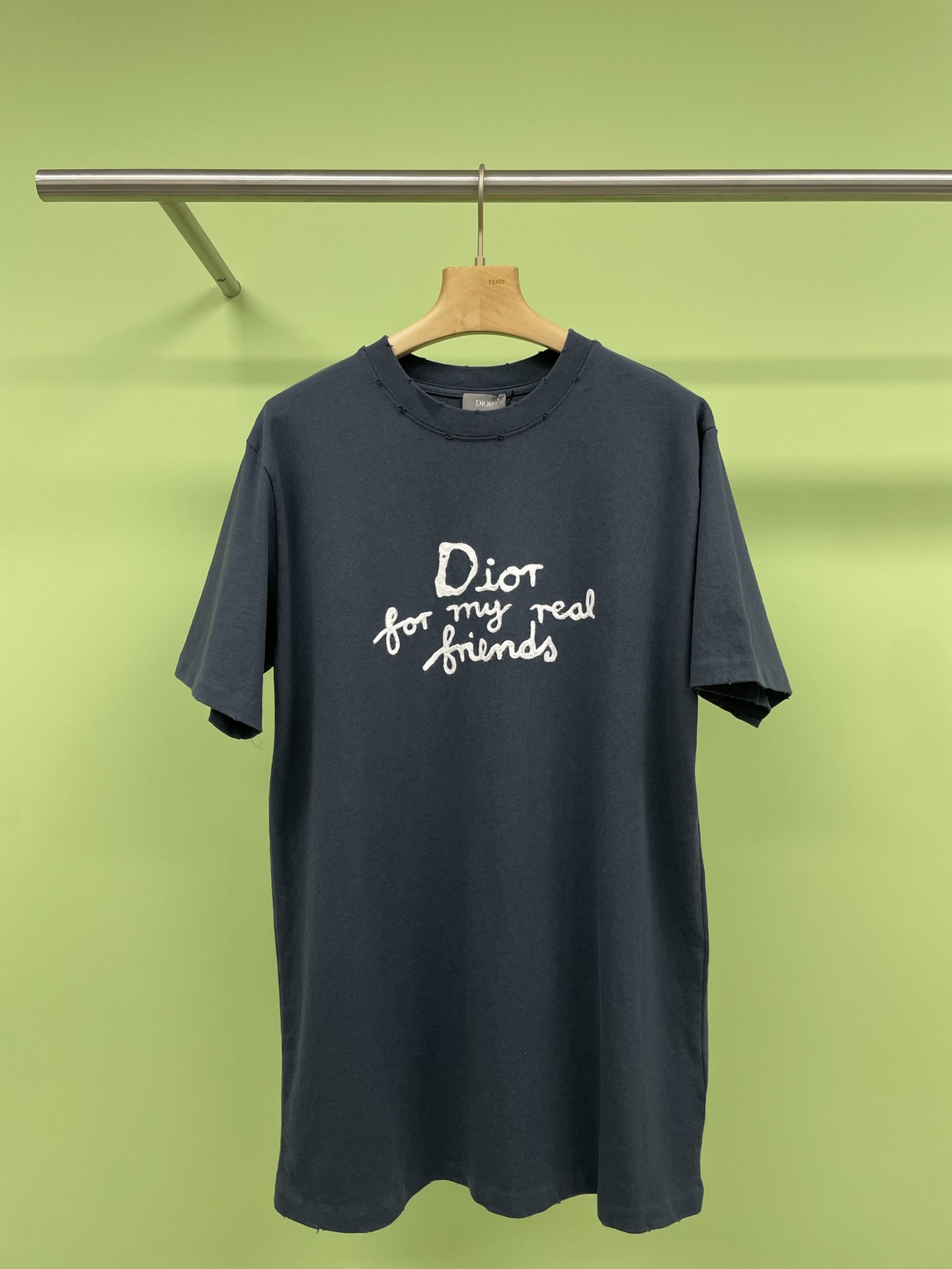 NO:319612,Dior2025 Spring and Summer HYLTON joint series loose round neck short-sleeved T-shirt is carefully crafted from navy blue cotton jersey fabric. The classic silhouette is matched with ribbed round neck. The chest is decorated with embroidery to enhance the style. The neckline, sleeves and bottom edges show a burning effect. The casual tailoring can be matched with sports trousers or jeans. The cotton jersey fabric is a knitted fabric made of cotton fiber. The fabric has good moisture absorption and breathability. The softness and skin-friendliness of cotton fibers make the fabric feel comfortable to touch. The fabric structure makes the fabric fit  It has a certain strength and stability, but compared with other complex knitting methods, its elasticity may be less. The chain embroidery needlework is a stitch formed in the form of chains. Its characteristic is that the embroidered pattern has a chain-like texture. The soft texture and good elasticity of the fine wool make the embroidery more three-dimensional and textured. The lace stone grinding water hole ripping process is a process that simulates the natural wear effect. The hole ripping process can form a natural texture on the surface of the garment. This texture contrasts with the untreated parts, enhancing the layering of the garment.  Code number XS SML,,dior,jeans,T-shirt,tees,t-shirt,alexander wang19860909Dior2025春夏HYLTON联名系列宽松版圆领短袖T恤,采用海军蓝色棉质平纹针织面料精心制作,经典廓形搭配罗纹圆领,胸前饰以刺绣提升格调,领口、衣袖和底边呈现烧花效果,休闲剪裁,可搭配运动长裤或牛仔裤,棉质平纹针织面料是一种由棉纤维制成的针织面料,面料具有良好的吸湿性和透气性,棉纤维的柔软性和亲肤性使得面料触感舒适.面料结构使得面料具有一定的强度和稳定性,但相对其他复杂编织方式,其弹性可能较小,锁链绣针法是一种以锁链形式构成的线迹,其特点在于绣出的图案具有链条般的肌理,搭配细毛线的柔软质地和良好弹性使得绣品更加立体且富有质感,成衣石磨洗水破洞工艺是一种模拟自然磨损效果的工艺,破洞工艺可以在成衣表面形成一层自然的纹理,这种纹理与未处理的部位形成对比,增强了成衣的层次感. 码数 XS SML,,dior,jeans,T-shirt,tees，t-shirt,alexander wang,Women's clothing