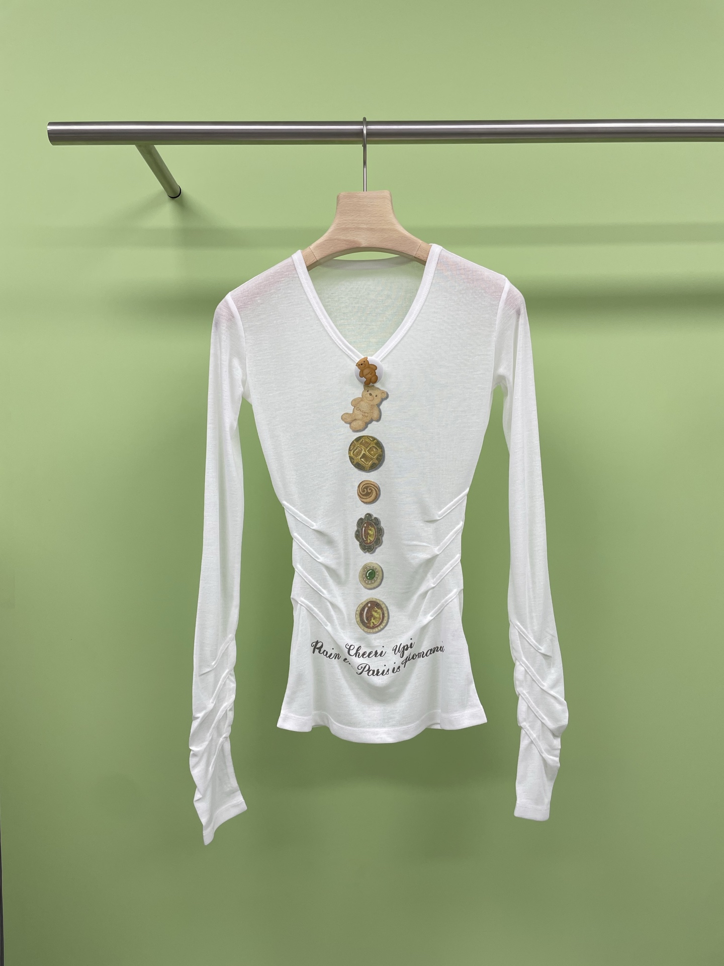 NO:423641,CHEERi UPi 2025 spring and summer new bear button V-neck base shirt, the white long-sleeved T-shirt base shirt is a must-have for hot girls. The V-neck design cleverly lengthens the neck lines, sexy and elegant, has a swan neck every minute, long sleeves are suitable for various seasons, layered and single wear is excellent, slim fit is a slim tool, perfect outlines the body curve, short tricks, pull up the waistline, and become long legs in seconds, paired with high-waisted pants or short skirts, instantly transform into a street fashionista. Whether it is a daily street, date or party, it can easily hold the scene, and the versatile attributes are directly full. SML, skirts, tees, t-shirt, alexander wang19860909CHEERi UPi2025春夏新款小熊纽扣V领打底衫,出门被问爆的白色长袖T,谁穿谁惊艳,这件白色V领长袖T恤打底衫,简直是辣妹必备,V领设计巧妙拉长颈部线条,性感又不失优雅,分分钟拥有天鹅颈,长袖适配各种季节,叠穿单穿都很绝,修身版型简直是显瘦神器,完美勾勒身材曲线,短款的小心机,拉高腰线,秒变大长腿,搭配高腰裤或短裙,瞬间化身街头潮人,不管是日常出街、约会还是派对,它都能轻松 hold住场面,百搭属性直接拉满. 码数SML,,skirts,tees，t-shirt,alexander wang,Women's clothing