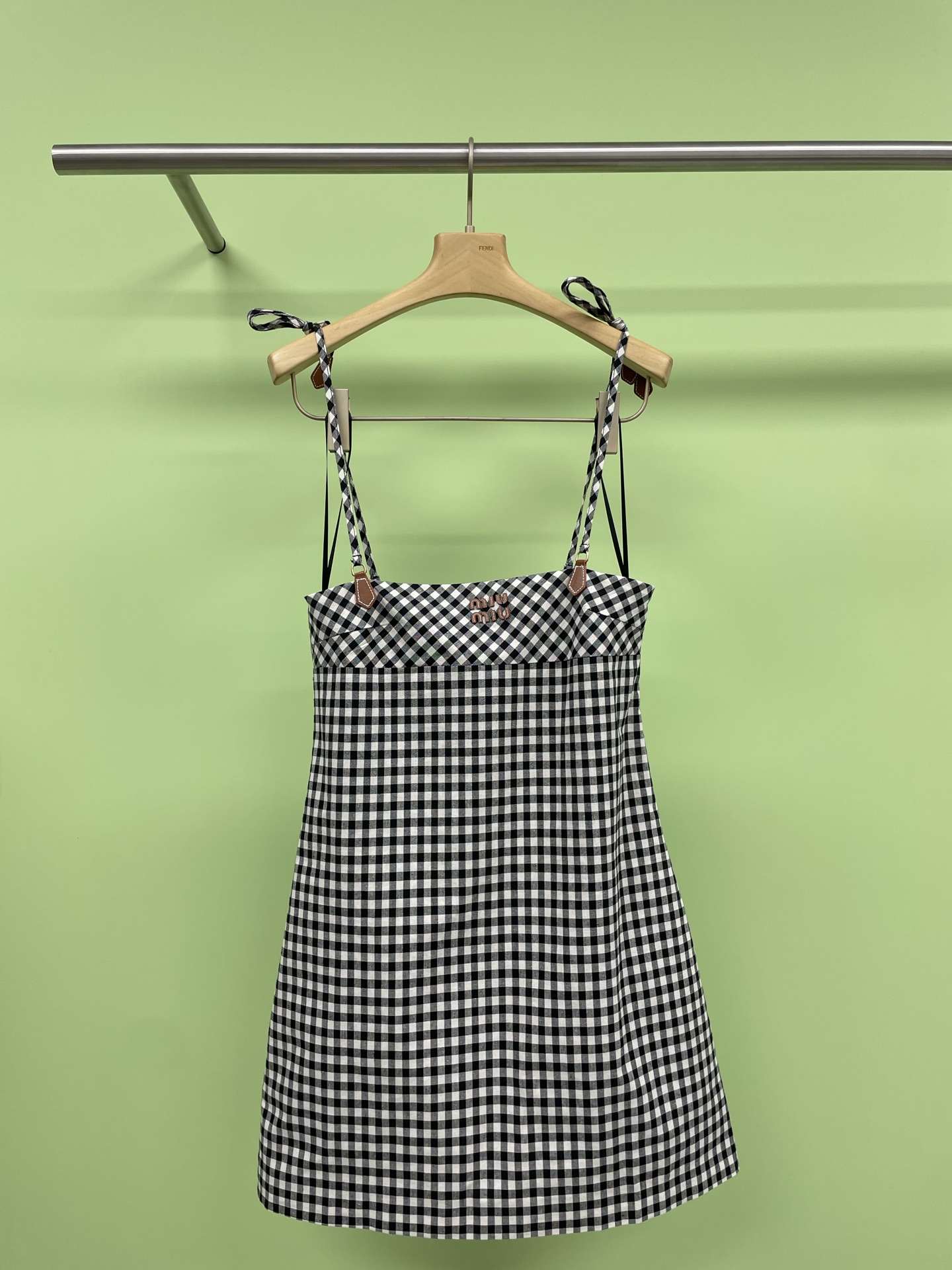 NO:426137,MiuMiu's new spring and summer 2025 new black and white plaid skirt with adjustable straps is here. The strap bow on the shoulder is simply my girlish dream. The paired small leather logo adds a hint of academic texture. The classic plaid elements are retro and fashionable. The suspender design reveals the slender arms. The small A-line skirt is playful and cute, and it also shows long legs. Paired with simple brown foot sandals and a small black shoulder bag on the back, the whole person exudes a summer freshness. Take a picture in front of the mirror in the room. The bright balcony and simple home decoration behind it are full of atmosphere. Do you like this retro and fresh outfit?  Come and place an order. SML, miumiu, sandals, satchels, skirts, alexander wang19860909MiuMiu2025春夏新款肩带可调节的黑白格子裙来啦,肩膀上的系带蝴蝶结,简直就是我的少女梦,搭配的小皮logo又增添了一丝学院质感的气息,经典的格纹元素,复古又时尚,吊带设计露出纤细的手臂,小A字裙摆俏皮可爱,还很显腿长,搭配上简约的棕色夹脚凉鞋,背上黑色的小挎包,整个人都散发着夏日的清新感,在房间里对着镜子拍一张,身后明亮的阳台和简约的家居布置,氛围感拉满,这样的复古清新风穿搭,你们喜欢吗？快来下单吧.码数SML,,miumiu,sandals,satchels,skirts,alexander wang,Women's clothing