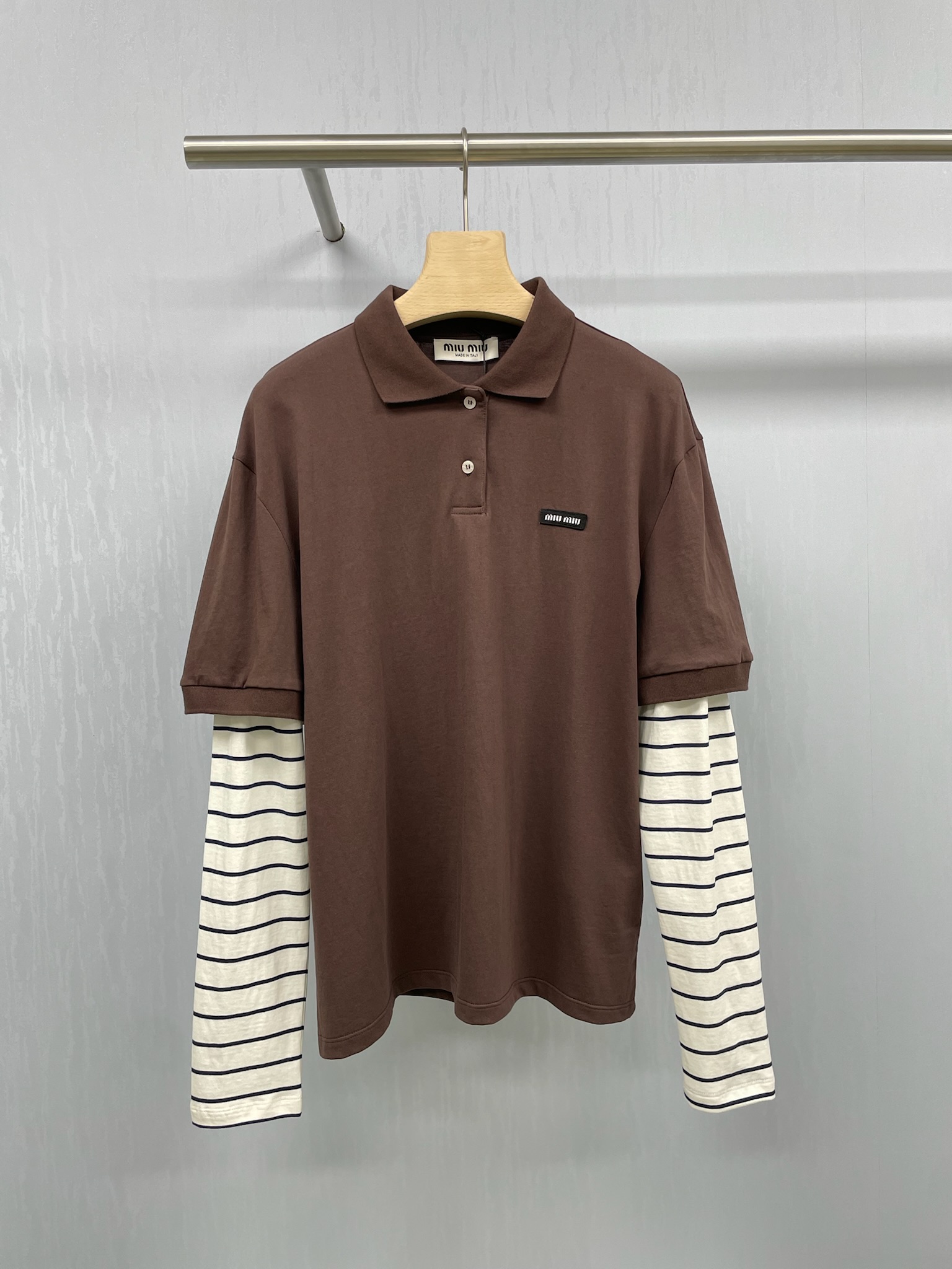 NO:449918,MiuMiu's new striped lapel fake two-piece long-sleeved T-shirt top for autumn, its style is really super slim. The loose tailoring can well modify the body lines. All the excess fat is invisible. The pure cotton fabric is soft and comfortable, which is very suitable for close-fitting wear. The small letter embroidered stripes design is simply playful. The unique striped elements, paired with the pattern of the small letter logo, instantly makes this T-shirt unique. Whether worn alone or as a base, it can easily attract attention and make you the focus of the crowd. In terms of matching, this T-shirt is also super versatile. Whether it is matched with jeans, skirts or casual pants, it can be easily controlled. It is simple but fashionable, allowing you to reach a new level of beauty in autumn.  SML, miumiu, skirts, jeans, tees, t-shirt, alexander wang19860909MiuMiu2025秋季新款条纹翻领假两件长袖T恤上衣,它的版型真的是超级显瘦,宽松的剪裁能够很好地修饰身材线条,多余的赘肉统统隐形,纯棉的面料质感柔软又舒适,非常适合贴身穿着,小字母刺绣条纹的设计简直是太俏皮啦,独特的条纹元素,搭配上小字母logo的图案,瞬间让这款T恤变得与众不同,无论是单穿还是作为打底,都能轻松吸引眼球,让你成为人群中的焦点,搭配方面,这款T恤也是超级百搭,无论是搭配牛仔裤、半身裙还是休闲裤,都能轻松驾驭,简约而不失时尚感,让你在秋日里美出新高度. 码数SML,,miumiu,skirts,jeans,tees，t-shirt,alexander wang,Women's clothing