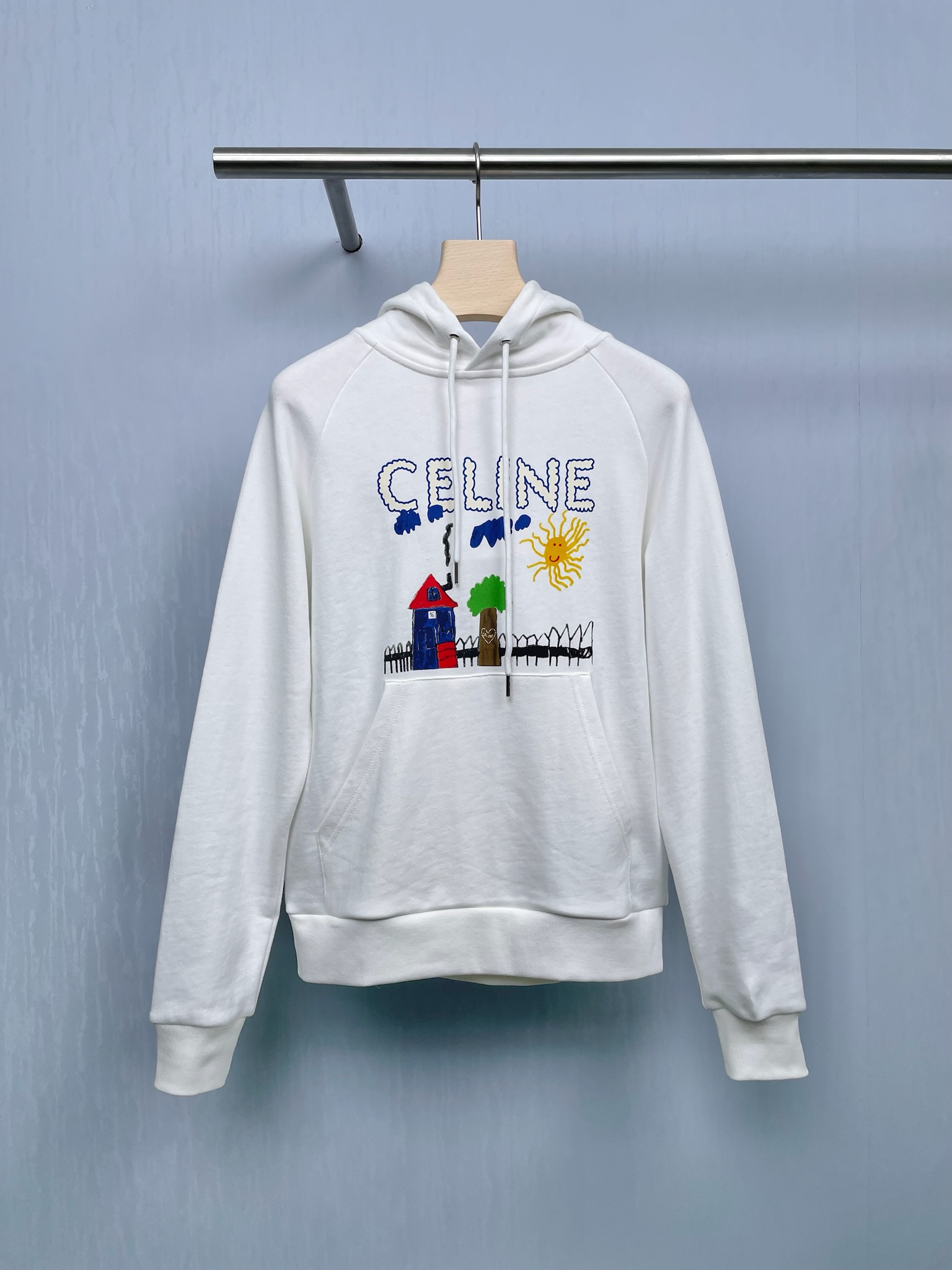 NO:454679,CELINE's new autumn children's fun hooded sweatshirt was cured by this hooded sweatshirt, with pure white base, and children's fun graffiti appearing on it, as if wearing sunshine and a hut on it, the vitality is reduced to age. The front children's fun paintings, a small house with red roof and blue body (there is a black chimney on the roof!), a shiny green tree, a yellow sun with a smile on its face, and even a black fence is painted next to the house - like a scene in a childhood picture book, directly 'sewn' a celine small  The brand name of the heart is not a hard big logo, but is printed on the neckline with textured fonts (the edges of the letters are soft, which feels like a cat pessimistic, and the letters decorated with blue clouds are like 'sticking' the clouds directly on the clothes, high-end and not deliberately. In fact, the happiest thing in autumn and winter is to put on a warm sweatshirt and go out with a hot drink, and then be gentlely caught by the fragrance of osmanthus flowers in the wind, the praise of passers-by, and the self in the camera?  SML, celine, hoodie, sweatshirts, hats, alexander wang19860909CELINE秋季新款童趣连帽卫衣,被这件连帽卫衣治愈了,纯净白色打底,童趣涂鸦跃然其上,仿佛把阳光、小屋穿在身上,元气又减龄,正面的童趣画,红顶蓝身的小房子（屋顶还有个黑烟囱！）、绿得发亮的树、挂着笑脸的黄太阳,连房子旁边都画了黑色栅栏——像把童年画本里的场景,直接“缝”celine的小心品牌名不是硬邦邦的大logo,而是用质感的字体印在领口（字母边缘软fufu的,摸起来像撸猫,还有蓝色云朵装饰的字母,像把云朵直接“粘”在了衣服上,高级又不刻意,其实秋冬最幸福的事,不就是套上一件暖乎乎的卫衣,揣着热饮出门,然后被风里的桂花香、路人的夸赞、和镜头里的自己——温柔地接住吗？ 码数SML,,celine,hoodie,sweatshirts,hats,alexander wang,Women's clothing