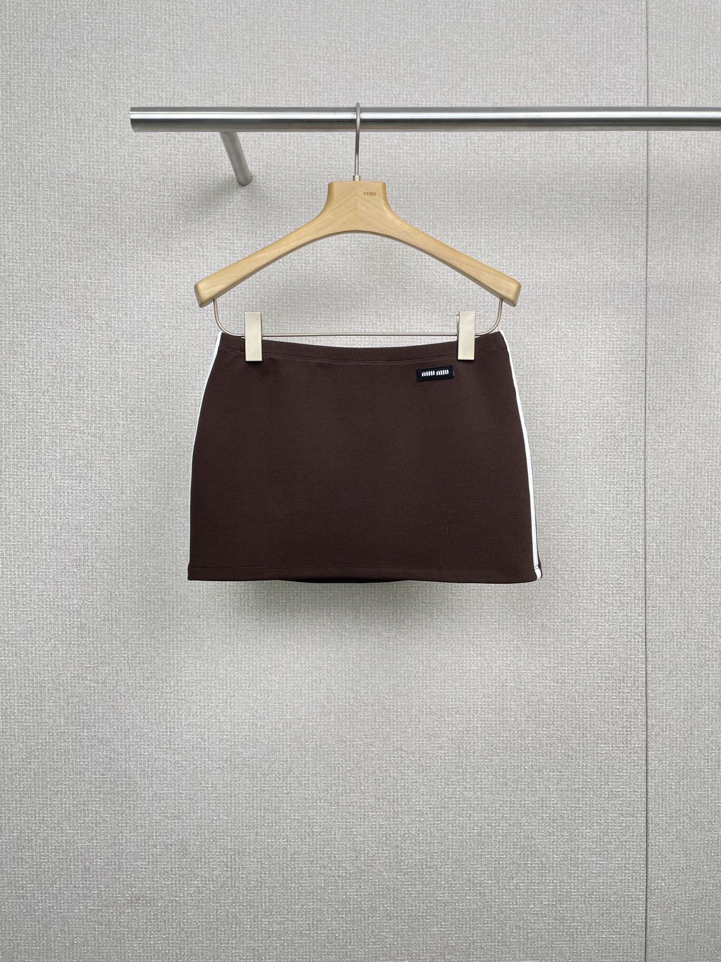 NO:460863,MiuMiu 2025 autumn and winter new elastic sportswear fabric tennis mini skirt, brown sports skirt, textured bead floor cloth and technology knitted fabric combine to outline the sports structure and outline of this mini skirt. The waist drawstring belt design inner seam pocket, contrasting embroidery logo highlights the brand characteristics. This technology fabric sports skirt is light but not only brings free breathing space to the body, but also a look of unforgettable. It is not only a companion during sports, but also a fashion statement in the city shuttle. Its versatile attributes can be easily controlled whether it is casual travel or light workplace wear, and it has full plasticity scores. SML, miumiu, skirts, alexander wang19860909MiuMiu2025秋冬新款弹力运动衣面料网球迷你裙,咖啡色运动风半裙,纹理珠地布与科技针织面料结合,勾勒出这款迷你裙的运动结构和轮廓,腰间抽绳腰带设计内缝口袋,撞色刺绣徽标彰显品牌特征,这款科技面料运动短裙,轻盈而不失功能,不仅为身体带来自由呼吸的空间,其设计感十足的剪裁,让人一眼难忘,它不仅仅是运动时的伴侣,更是都市穿梭中的时尚宣言,它的百搭属性,无论是休闲出游还是职场轻装,都能轻松驾驭,可塑性满分. 码数SML,,miumiu,skirts,alexander wang,Women's clothing
