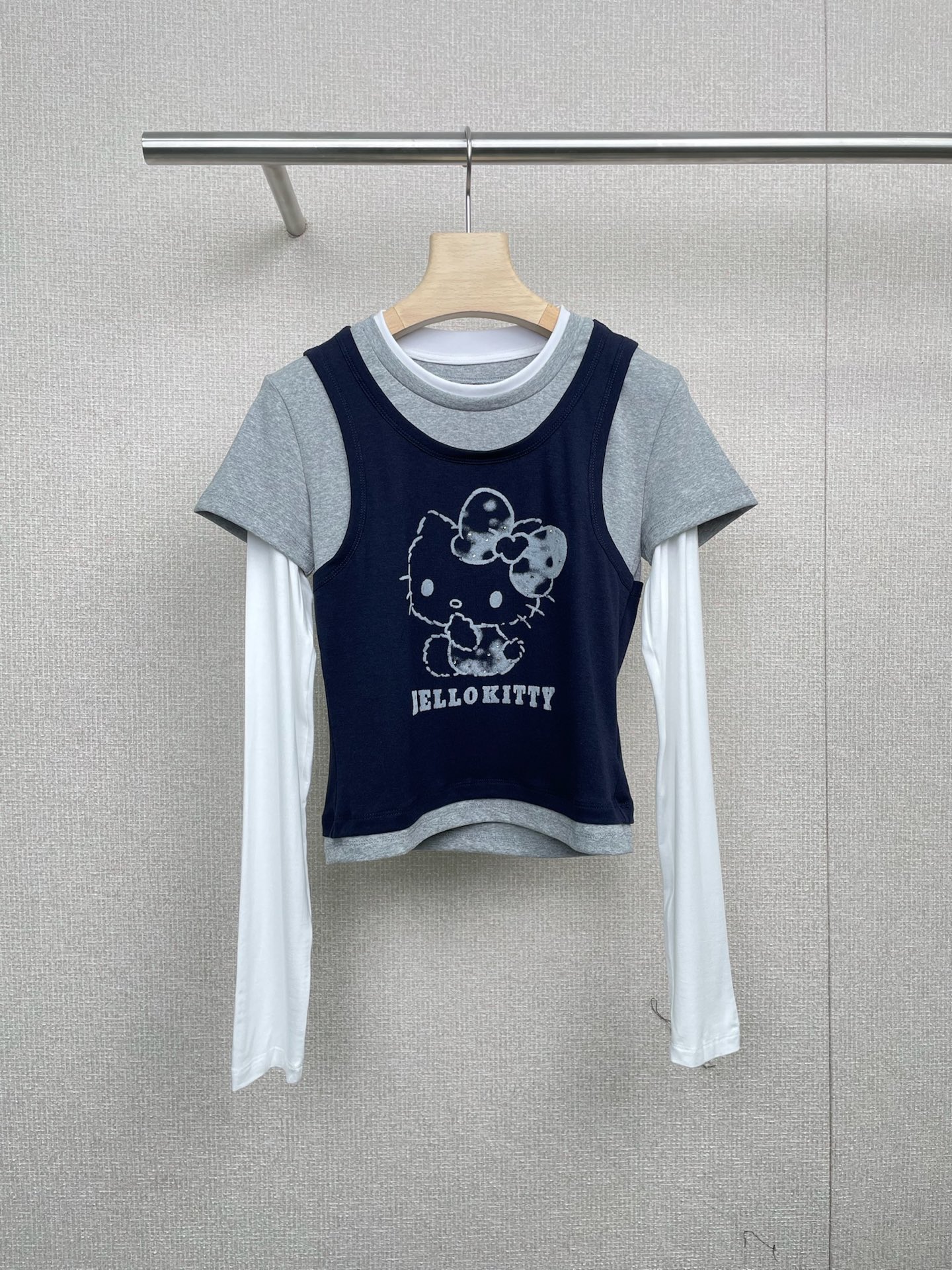 NO:466688,REVAN 2025 autumn new HelloKitty flocking pattern contrasting fake three-piece set, light gray body with off-white sleeves, bold and harmonious color collision, super visual impact, K on the chest  T flocking printing design adds a bit of street fashion. The looming printing pattern adds a mysterious atmosphere to the overall look. The slim fit style is not picky about the figure, and the effect of hiding the flesh is first-class. Whether it is a pear-shaped body or an apple-shaped body, it can be easily controlled. The biggest highlight of this T-shirt is the contrasting color splicing design. The clever fusion of different colors makes the whole T-shirt look layered and instantly enhances the fashion sense of the overall outfit. This contrasting color design can also set off the skin tone and make the complexion look super good. It cleverly uses visual illusion to create a three-piece outfit effect, which is both fashionable and slimming. Especially for those who want to modify the body lines, this T-shirt is definitely your blessing. SML, tees, t-shirt, alexander wang19860909REVAN芮范2025秋季新品HelloKitty植绒图案撞色假三件套,浅灰色衣身搭配米白色袖子,色彩碰撞大胆又和谐,视觉冲击力超强,胸口的K T植绒印花设计,增添了几分街头潮流感,若隐若现的印花图案,又给整体造型增添了一丝神秘氛围,修身的版型,不挑身材,藏肉显瘦效果一流,不管是梨形身材还是苹果型身材,都能轻松驾驭,这款T恤最大的亮点就是撞色拼接设计,不同色彩的巧妙融合,让整件T恤看起来层次感十足,瞬间提升整体穿搭的时尚感,这种撞色设计还能很好地衬托肤色,显得气色超级好,它巧妙地利用视觉错觉,营造出三件套的穿搭效果,既时尚又显瘦,特别是对于那些想要修饰身材线条的宝贝们来说,这款T恤绝对是你们的福音. 码数SML,,tees，t-shirt,alexander wang,Women's clothing