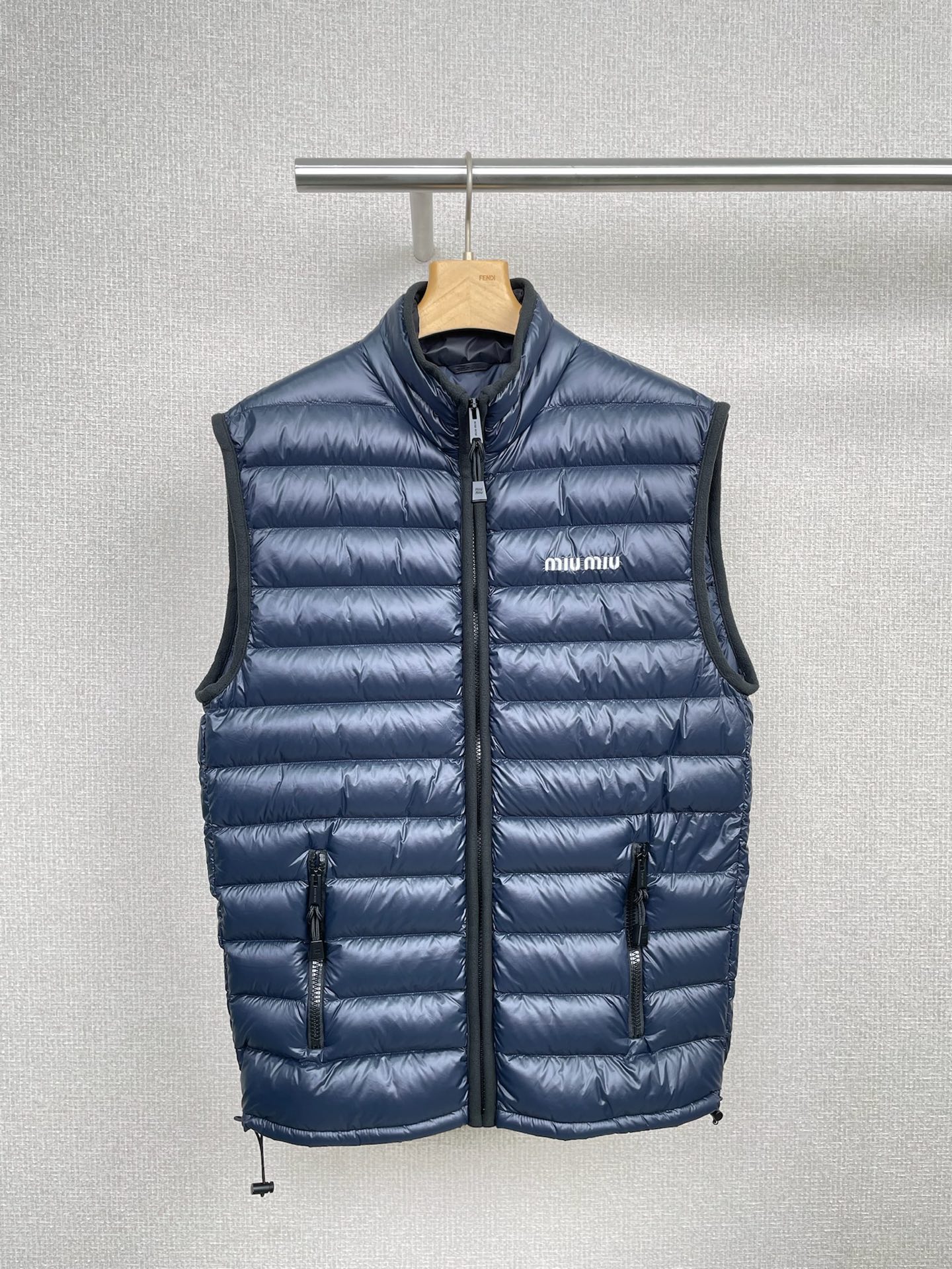 NO:480424,MiuMiu2025 new hidden blue letter logo lightweight down vest vest, although it is just a vest, it is warm and unambiguous. The filled high-quality white goose down takes care of the core parts of the body. It is like being surrounded by warm clouds when worn on the body. In autumn and winter, wear a sweater inside and cover it outside, and you won’t be afraid of the cold wind. It is simply a matching tool. It can be matched with a sweater, and it is full of leisure and youthful vitality.  It is very complete, and it is more capable and neat when paired with a shirt. It is very suitable for daily commuting. It is also awesome with a dress. It is elegant and warm, and it is easy to create different styles. It is very light to wear, without that heavy sense of restraint. It is super easy to move. It can be easily dealt with whether it is shopping or outdoor sports. In short, down vests are a treasure item for autumn and winter. Treasures must have one to make this autumn and winter warm and fashionable.  SML, miumiu, hoodie, sweatshirts, skirts, sweats,shirts, down jacket, alexander wang19860909MiuMiu2025新款藏蓝字母logo轻质羽绒马甲背心,别看它只是个马甲,保暖可一点不含糊,填充的优质白鹅羽绒,把身体核心部位都照顾得妥妥的,穿在身上就像被温暖的云朵包围着,在秋冬季节,内搭一件毛衣,外面套上它,冷风都不怕啦,简直是搭配神器,可以搭配卫衣,瞬间休闲感满满,青春活力十足,和衬衫搭配呢,又多了几分干练利落,很适合日常通勤哦,配连衣裙也是绝绝子,优雅又保暖,轻松打造不同风格,穿起来特别轻便,不会有那种厚重的束缚感,活动起来超自如,无论是逛街还是户外运动,都能轻松应对,总之羽绒马甲就是秋冬的宝藏单品呀,宝子们一定要拥有一件哦,让这个秋冬既温暖又时尚. 码数SML,,miumiu,hoodie,sweatshirts,skirts,sweaters,shirts,down jacket,alexander wang,Women's clothing