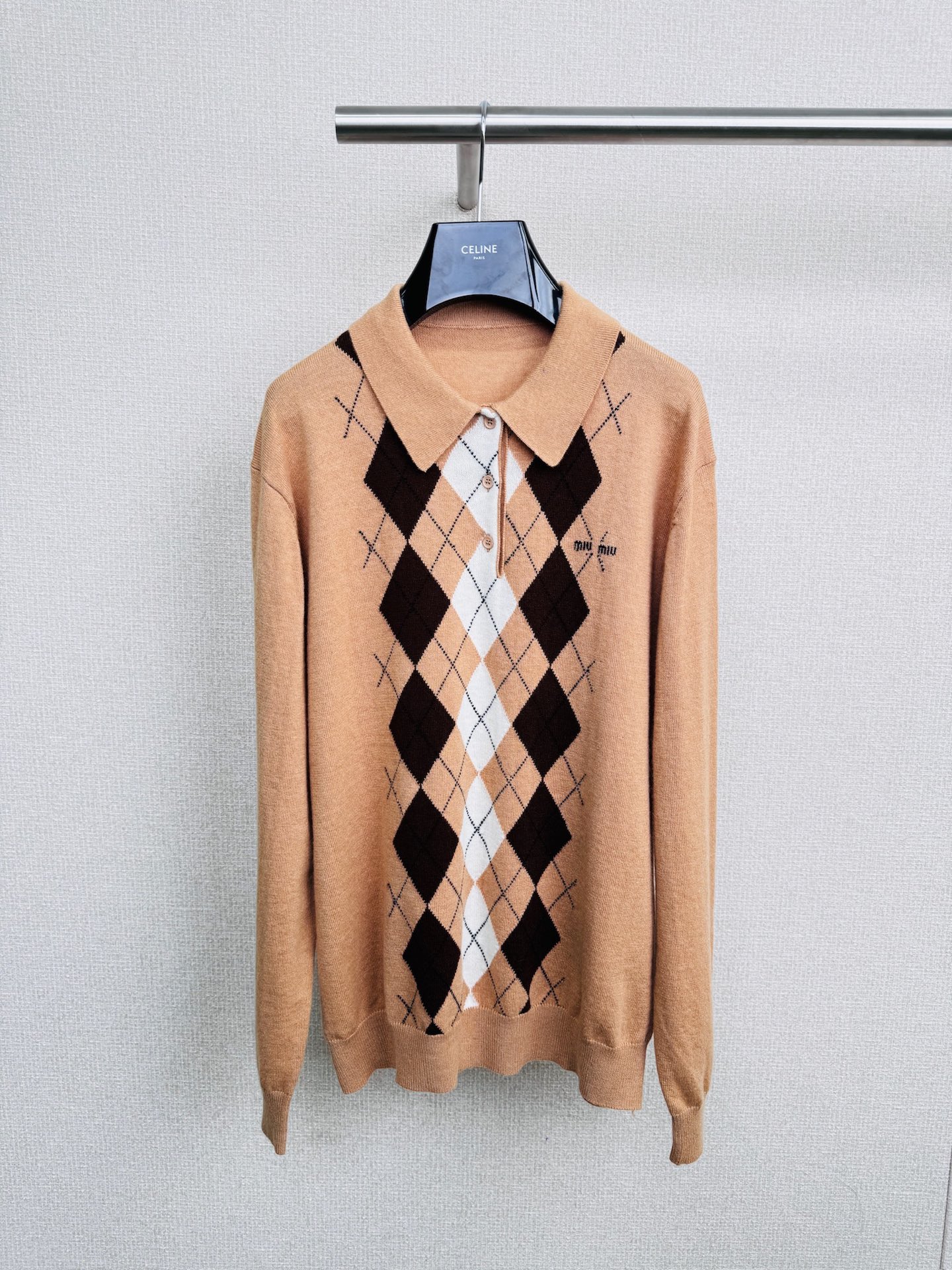 NO:491703,MiuMiu2025 diamond-shaped cashmere knitted long-sleeved POLO shirt, which combines leisure and elegance, reinterprets the new perspective of classic styles with details, soft and delicate cashmere materials, precision fine ribbed neckline, cuffs and hem, smooth and simple half-slap line design, chest embellishment of eye-catching jacquard logos to highlight style, front breakpoint diamond geometric patterns present contrasting color design, polo lapel design and slim tailoring outline beautify the upper body proportions, stacking single-edge switching, gender-free neutral style, presenting a modern style top item, retro diamond-shaped weaving, each stitch is exuding craftsmanship, buttons embellish it, simple but elegant, warm every day of your life, cashmere material, soft and skin-friendly, warm and upgraded, let fashion and temperature coexist, come and embrace this classic and warmth.  SML, miumiu, alexander wang19860909MiuMiu2025菱格嵌花羊绒针织长袖POLO衫,闲适与优雅兼具的设定上,以细节重释经典款的新视角,柔软细腻山羊绒用料,精密细罗纹领口、袖口和下摆,流畅简洁半插肩线条设计,胸前点缀醒目的提花徽标,彰显格调,正面断点菱形几何图案呈现撞色设计,polo翻领设计与修身剪裁勾勒美化上身比例,叠搭单穿切换自如,无性别主义中性风格,呈现摩登格调的上装单品,复古菱格编织,每一针都透着匠人情怀,纽扣点缀其间,简约而不失雅致,温暖你的每一个日常,羊绒材质,柔软亲肤,保暖升级,让时尚与温度并存,快来拥抱这份经典与温暖吧. 码数SML,,miumiu,alexander wang,Women's clothing