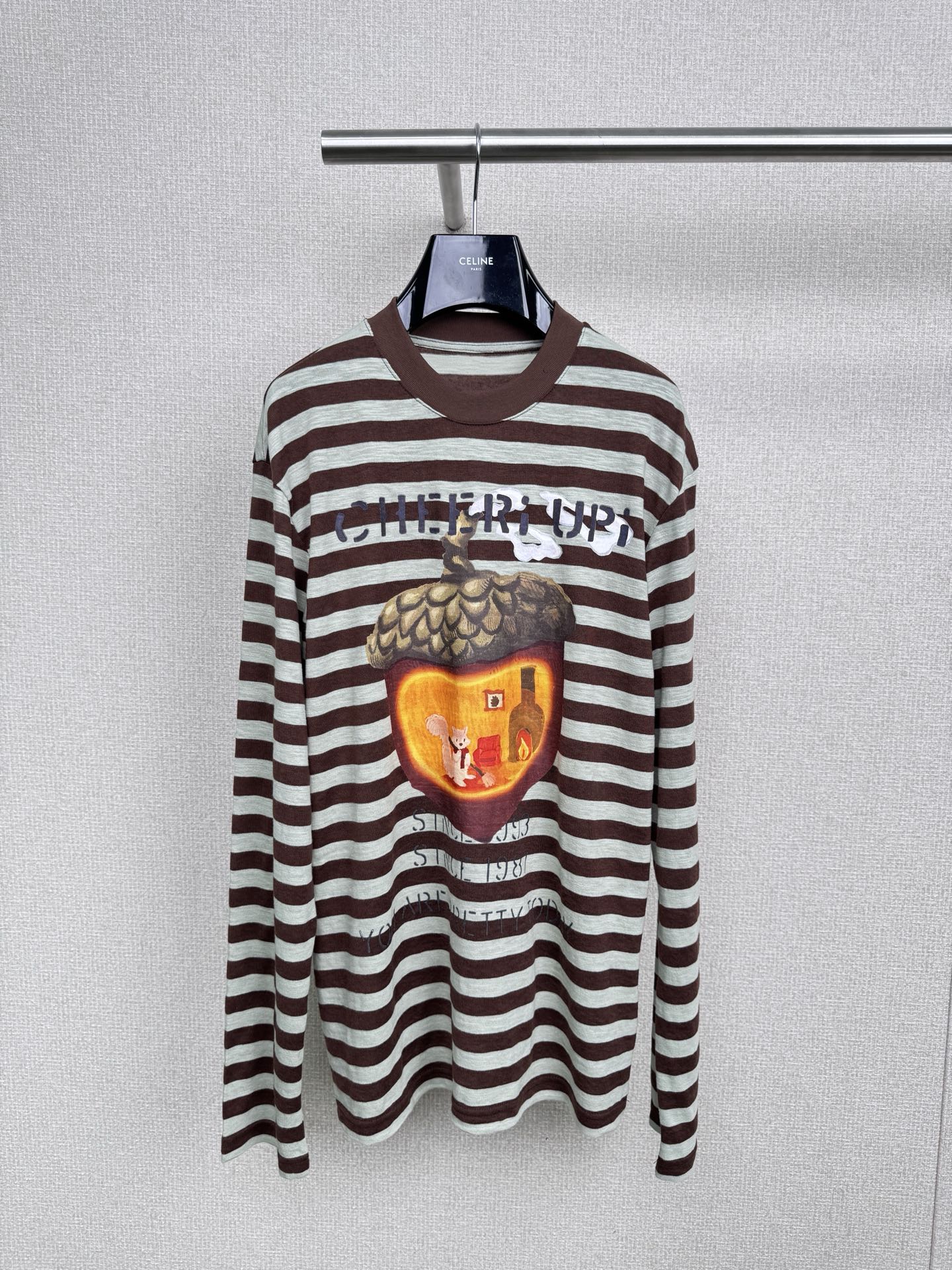 NO:535018,CHEERi UPi's new autumn style loose squirrel acorn house long-sleeved T-shirt, which is so cute that it screams by this 'Squirrel's Acorn House'. The design of CHEERi UPi is really good, with brown and green stripes retro and fresh. The pattern of the squirrel in the acorn house on her chest is full of childlike fun, like wearing fairy tales on her body. The loose style is super hidden, lazy and energetic, comfortable fabric, warm autumn companion, the fabric is really amazing. It uses soft and skin-friendly cotton material, which is very comfortable to wear close to the body, and it will not feel like it is tying the skin at all. Moreover, the long-sleeved design can warm you just the right time in the cool weather in early autumn. It will not feel stuffy, but also resist the chill. It is the kind of comfort that can be worn from morning to night. Whoever wears it is a sweet girl, the first cute long-sleeved one in autumn must be it.  SML, tees, t-shirt, alexander wang19860909CHEERi UPi秋新款宽松松鼠的橡果屋长袖T恤,被这件“松鼠的橡果屋”长袖可爱到尖叫,CHEERi UPi的设计真的太会了,棕绿条纹复古又清新,胸前松鼠在橡果屋里的图案,童趣满满,像把童话穿在身上,宽松的版型超藏肉,慵懒又有活力,舒适面料,秋日温暖陪伴,面料真的绝绝子,采用了柔软亲肤的棉质材料,贴身穿特别舒服,完全不会有扎皮肤的感觉,而且长袖的设计在初秋微凉的天气里,能恰到好处地给你温暖,既不会觉得闷热,又能抵御丝丝寒意,是那种可以从早穿到晚的舒适,谁穿谁是甜妹,秋天第一件可爱长袖,必须是它. 码数SML,,tees，t-shirt,alexander wang,Women's clothing