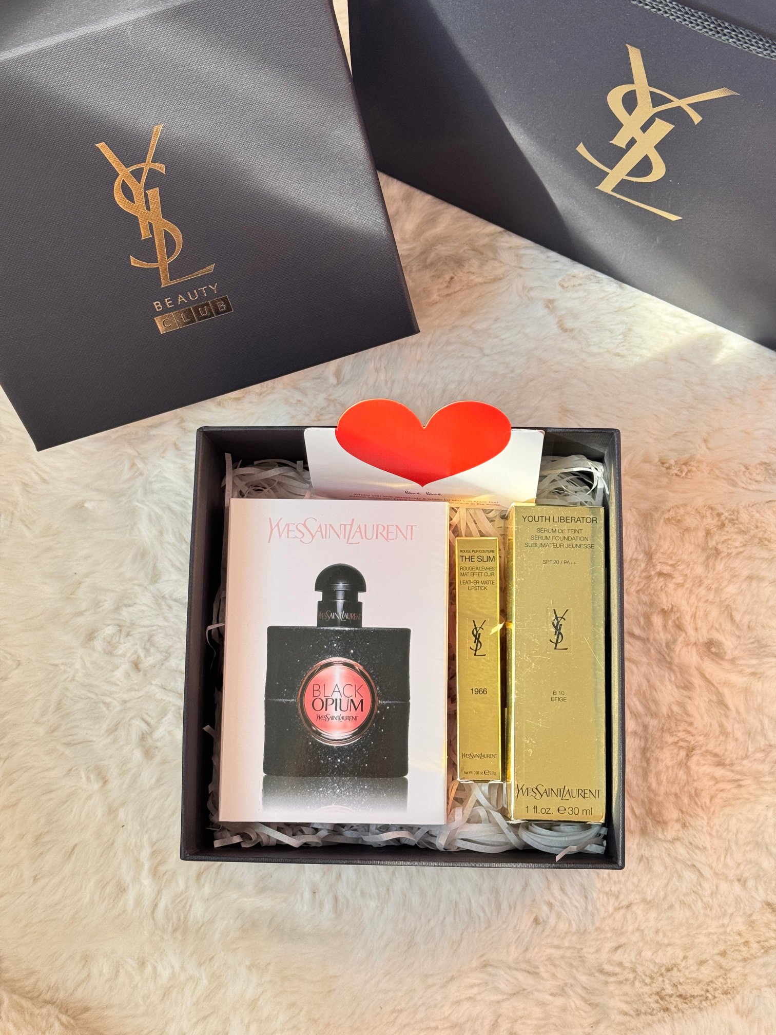120！圣罗兰黑鸦片女神三件套！ #铁了心都要入，一生只做一件事，一生只爱一个人，我爱你，你随意#！你的倾国倾城，我的一眼万年，送与最爱之人！ 内含：ysl黑鸦片90ml+ysl1966#色号口红+ysl逆龄粉底液B10#色号+爱心卡片+拉菲草！ ［Ysl逆龄粉底液］传说中的女神粉底液。 越用越持久的底妆让你变成夜间小精灵 首款有护肤功效的粉底液质地偏稠 流动性不大但是延展性很不错 滋润度很高遮瑕力也可 就算是冬天用和皮肤贴合的很好不起皮不浮粉 「YSL黑鸦片香水」 这只YSL可能是你的那杯茶！！与众不同的咖啡元素的注入，闻了会上瘾一点也不夸张！！ 前调：橙花 粉红胡椒 梨中调：咖啡 茉莉 杏仁 甘草 后调：广藿香 雪松木 香草 它的留香持久度很长，尾调真的很好闻很好闻！！ 「YSL圣罗兰小金条1966#」 浓郁暖调红棕色，简直美到哭泣！ 薄涂是一种元气满满的橘调，显得整个人都活力四射，日常通勤的姐妹可以薄涂！ 厚涂就是那种超有氛围感的红棕色，气场瞬间全开，立马变身气场一米八的拽姐，走在街上都是焦点中的焦点！显白神器当之无愧！！