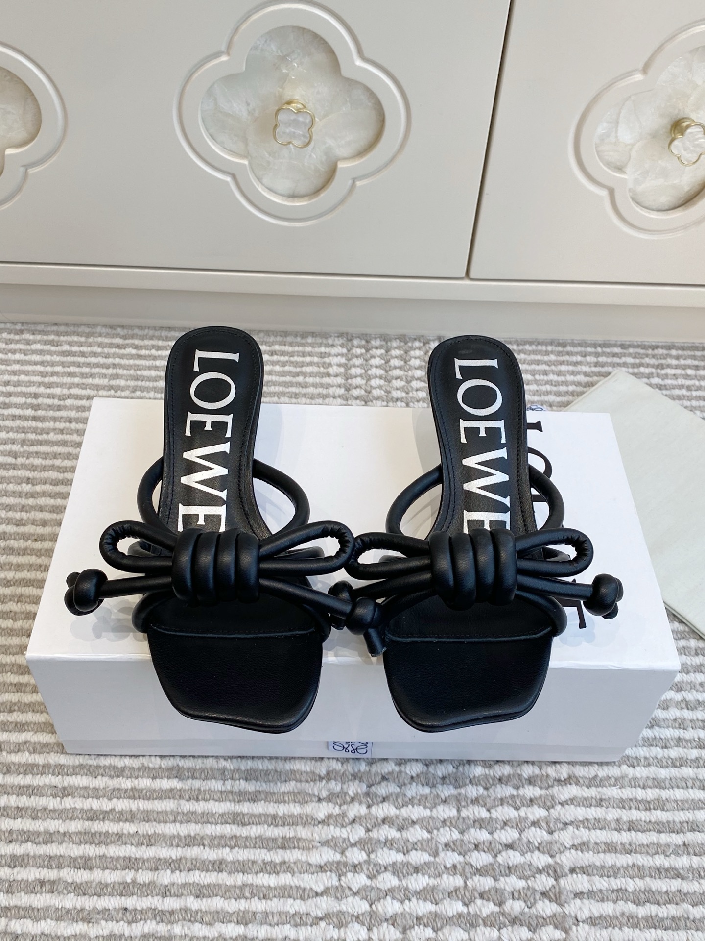 NO:760331,Loewe · Loewe · Early spring new model · Temperamental and fashionable bow cat-heeled sandals Wear gentleness and casualness on your feet, which is the daily ritual that LOEWE gives you. The square toe outline is wrapped in delicate leather, and the iconic rope bow gently hangs down on the upper, with a French lazy aftertaste in every step. The low-heeled design just fits the shape of the foot, and you can switch states freely when commuting, shopping or weekend coffee. The upper is imported calfskin and the lining is sheepskin.  Outsole Imported genuine leather outsole, heel height 4.5cm, size 35-40 (41 and 42 sizes customized, non-returnable), high heels and slippers, loewe, loewe, high heels, slippers, cowhide, sheepskin, Leather soles19860909批 Loewe·罗意威·早春新款·气质时尚蝴蝶结猫跟凉拖鞋 把温柔和随性穿在脚上,是LOEWE给你的日常仪式感.细腻皮革包裹方头轮廓,标志性绳结蝴蝶结在鞋面轻轻垂落,每一步都带着法式慵懒的余韵.低跟设计刚好贴合脚型,通勤、逛街或是周末咖啡局,都能自在切换状态. 鞋面进口小牛皮 内里羊皮 大底进口真皮大底 跟高4.5cm size35-40（41·42码定制不退换）,高跟鞋拖鞋,loewe,loewe,high heels,slippers,cowhide,sheepskin,Leather soles,Women's Shoes