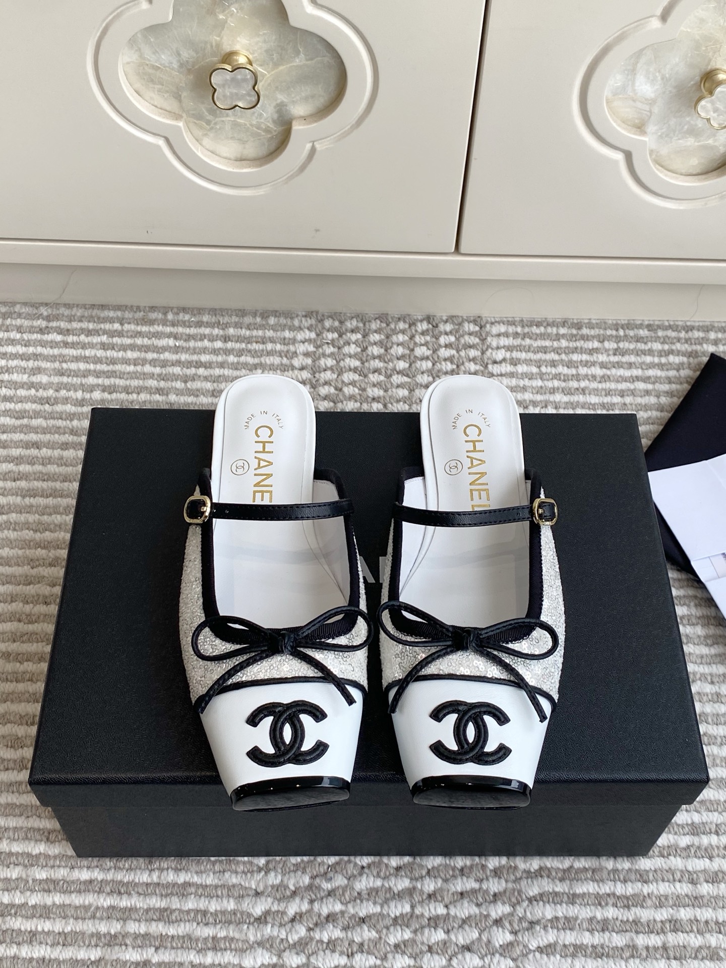 NO:923648,First batch of slippers Chanel 26SS Coco Mary Jane color-blocked toe bow square toe Mule slippers Chanel's spring and summer classic Coco retro Mary Jane series deconstructs the retro one-strap Mary Jane shoes into heelless Mule slippers, integrating the brand's iconic black and white square toe, bow decoration and double C embroidery logo, focusing on the relaxed commuting style of a sophisticated lady. It is the main shoe for daily lazy people this season.  Material Imported lambskin/beaded sequins/sheepskin lining Outsole Imported genuine leather outsole size35-39 (customized at 40.41), half slippers, chanel, chanel, mary jane, slippers, sheepskin, Leather soles19860909批拖鞋 单鞋 Chanel 26SS Coco Mary Jane 拼色包头蝴蝶结方头穆勒拖鞋 香奈儿春夏经典Coco复古玛丽珍系列,将复古一字带玛丽珍鞋解构为无后跟穆勒拖鞋,融合品牌标志性黑白拼方头、蝴蝶结饰与双C刺绣标识,主打轻熟千金松弛通勤风,是本季日常懒人主力单鞋. 材质进口小羊皮/串珠亮片/羊皮内里 大底进口真皮大底 size35-39（40.41定做）,半拖单鞋,chanel,chanel,mary jane,slippers,sheepskin,Leather soles,Women's Shoes