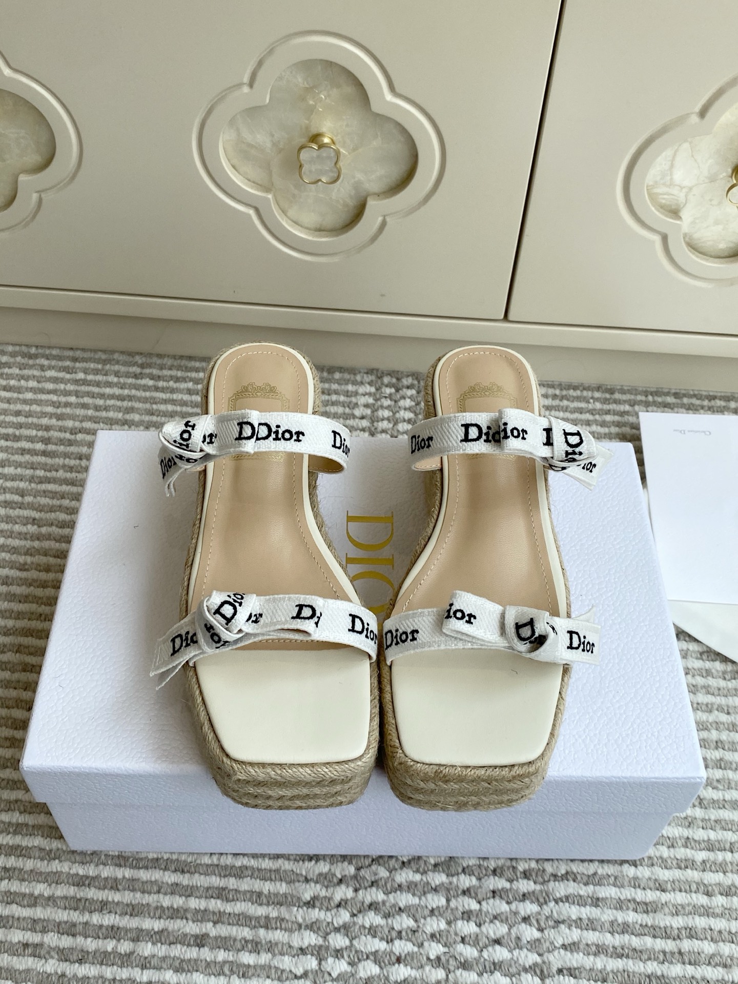 NO:923552,Upgraded version batch Dior J'Adior Web Bow Straw Wedge Sandals·Slippers This sandal is presented by Jonathan Anderson, a new interpretation of the Dior classic series, highlighting the brand's exquisite craftsmanship. The double-strap design is matched with a two-color Dior embroidered ribbon, and the top is tied into a flat bow, making the iconic design fully recognizable. The sheepskin lining is matched with a 7.5cm wedge heel, and raffia woven to create a lightweight thick sole, taking into account retro texture and daily comfort, injecting elegance into the summer look.  size35-41,slippers,dior,sandals,slippers,espadrilles,sheepskin19860909升级版批 Dior J'Adior 织带蝴蝶结草编坡跟凉鞋·拖鞋 这款凉拖由乔纳森·安德森倾情呈献,全新演绎Dior经典系列,彰显品牌精湛工艺.双带设计搭配双色Dior刺绣饰带,顶部系成扁平蝴蝶结,标志性设计辨识度拉满.羊皮内里搭配7.5cm坡跟,采用酒椰草编织打造轻盈厚底,兼顾复古质感与日常舒适,为夏日造型注入优雅格调. size35-41,拖鞋凉鞋,dior,sandals,slippers,espadrilles,sheepskin,Women's Shoes