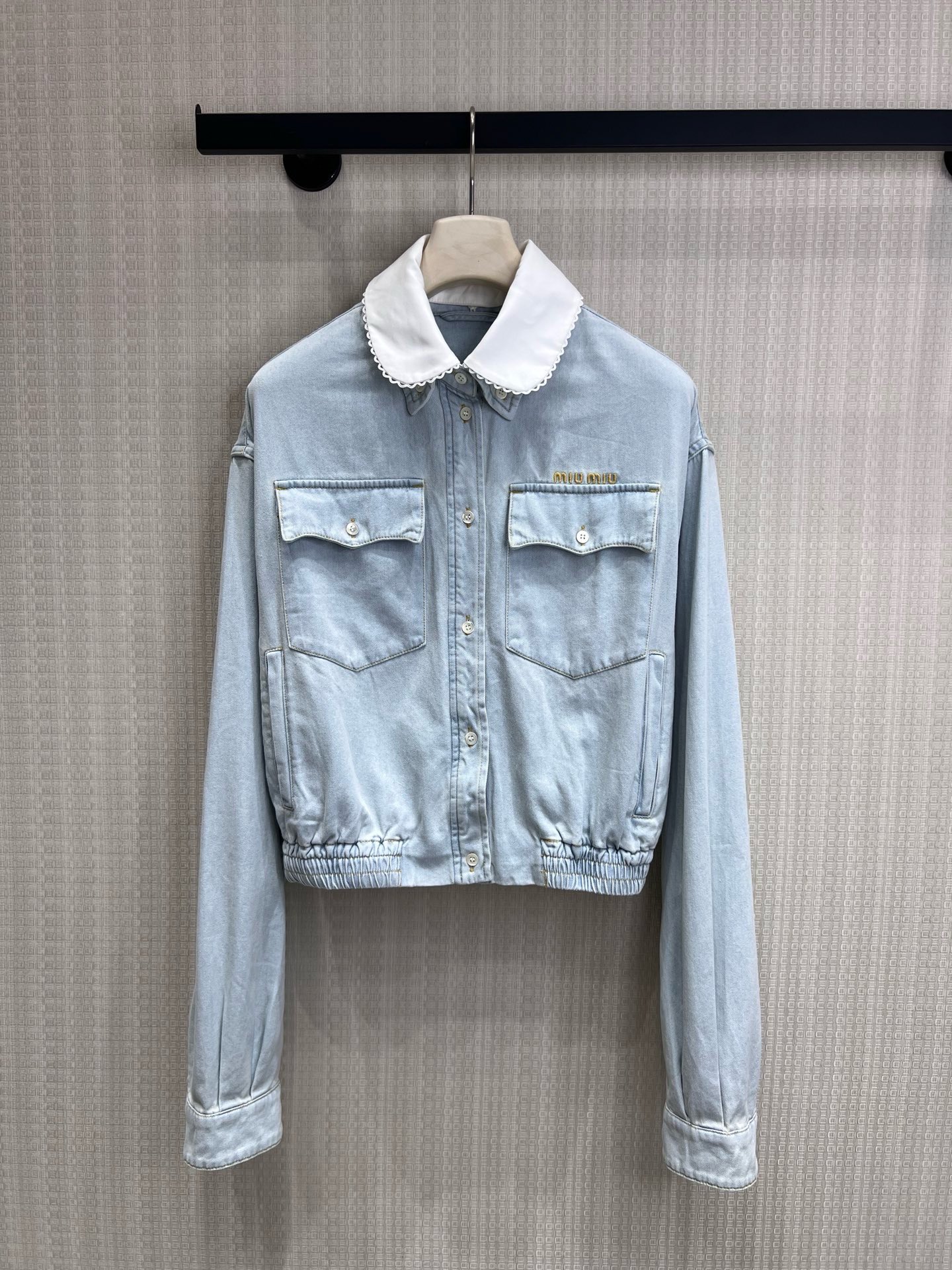 NO:891577,26 spring and summer new arrival Miu** doll collar denim jacket  The light-washed blue denim fabric has a retro soft-focus feel, and the detachable white lace baby collar is the finishing touch. The sweet element collides with the spontaneity of denim. The gold embroidered logo on the body is a low-key identity, and the elasticated hem creates a neat short version, which can easily raise the waistline and is suitable for high-waisted bottoms. The dropped shoulder cut weakens the shoulder line and brings a lazy and relaxed feeling. It is an iconic item of sweet and cool girl style. Ready for sale smL,, miumiu, jackets & coats,1986090926春夏新品 Miu**娃娃领牛仔外套 浅水洗蓝牛仔面料自带复古柔焦感,可拆卸白色蕾丝娃娃领是点睛之笔,甜美元素碰撞牛仔的率性.衣身金色刺绣Logo低调标识身份,下摆松紧收口打造利落短款版型,轻松拉高腰线,适配高腰下装.落肩剪裁弱化肩线,自带慵懒松弛感,是甜酷少女风的标志性单品.现货出售smL,,miumiu,jackets & coats,,Women's clothing